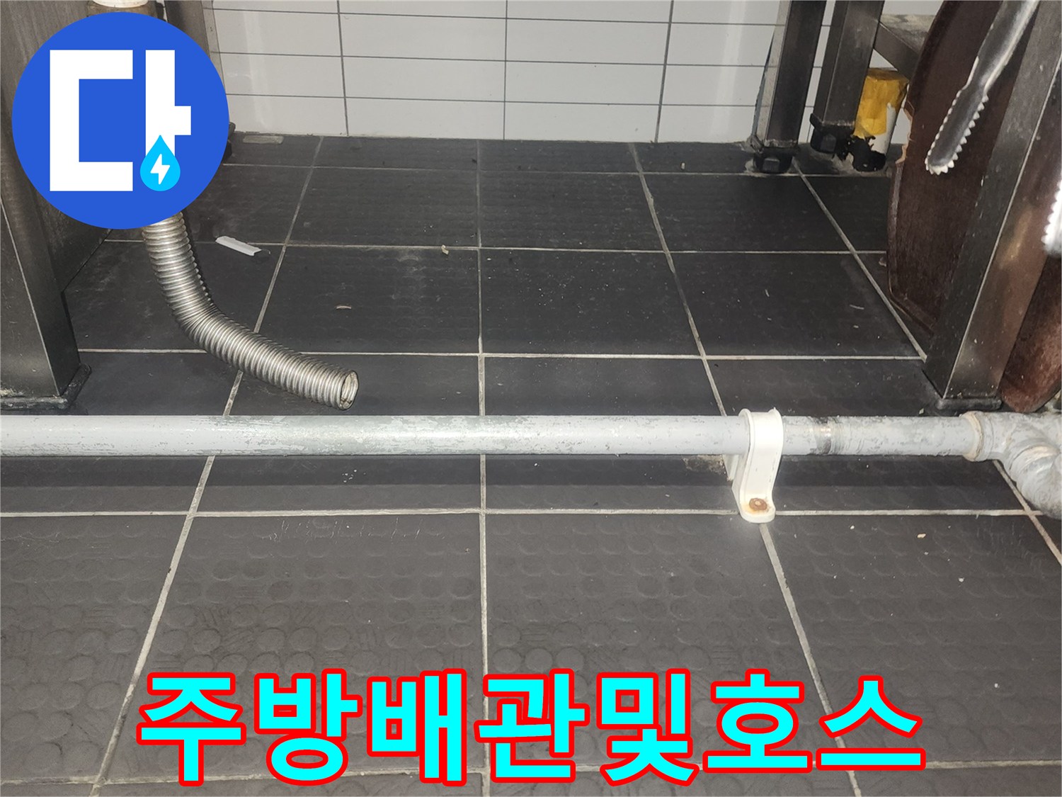 식당 주방 벽면 타일과 배관 연결부의 상세 모습