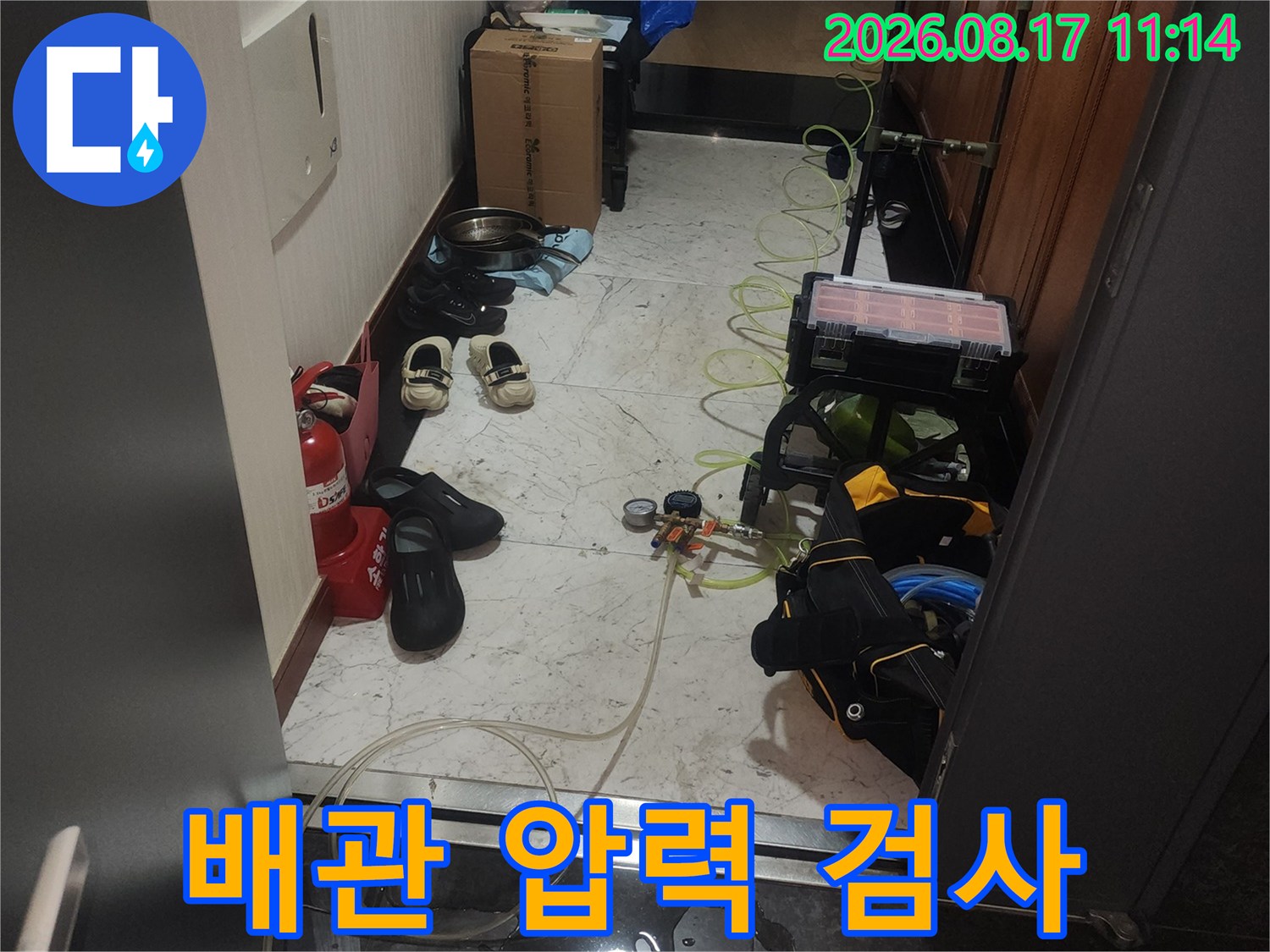 싱크대 하부 공간에 배치된 공압 테스트용 장비와 배관 연결 부위 근접 촬영