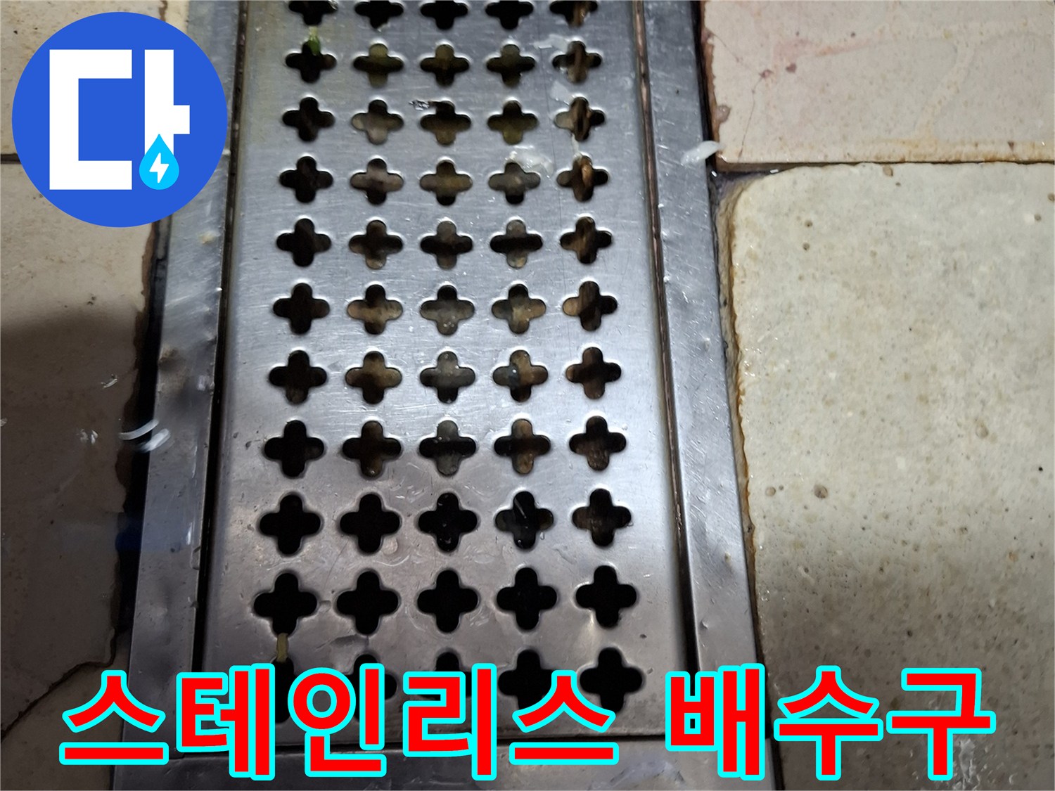 금속 재질의 배수 트렌치와 주변 타일 마감 부위 상세 사진입니다.