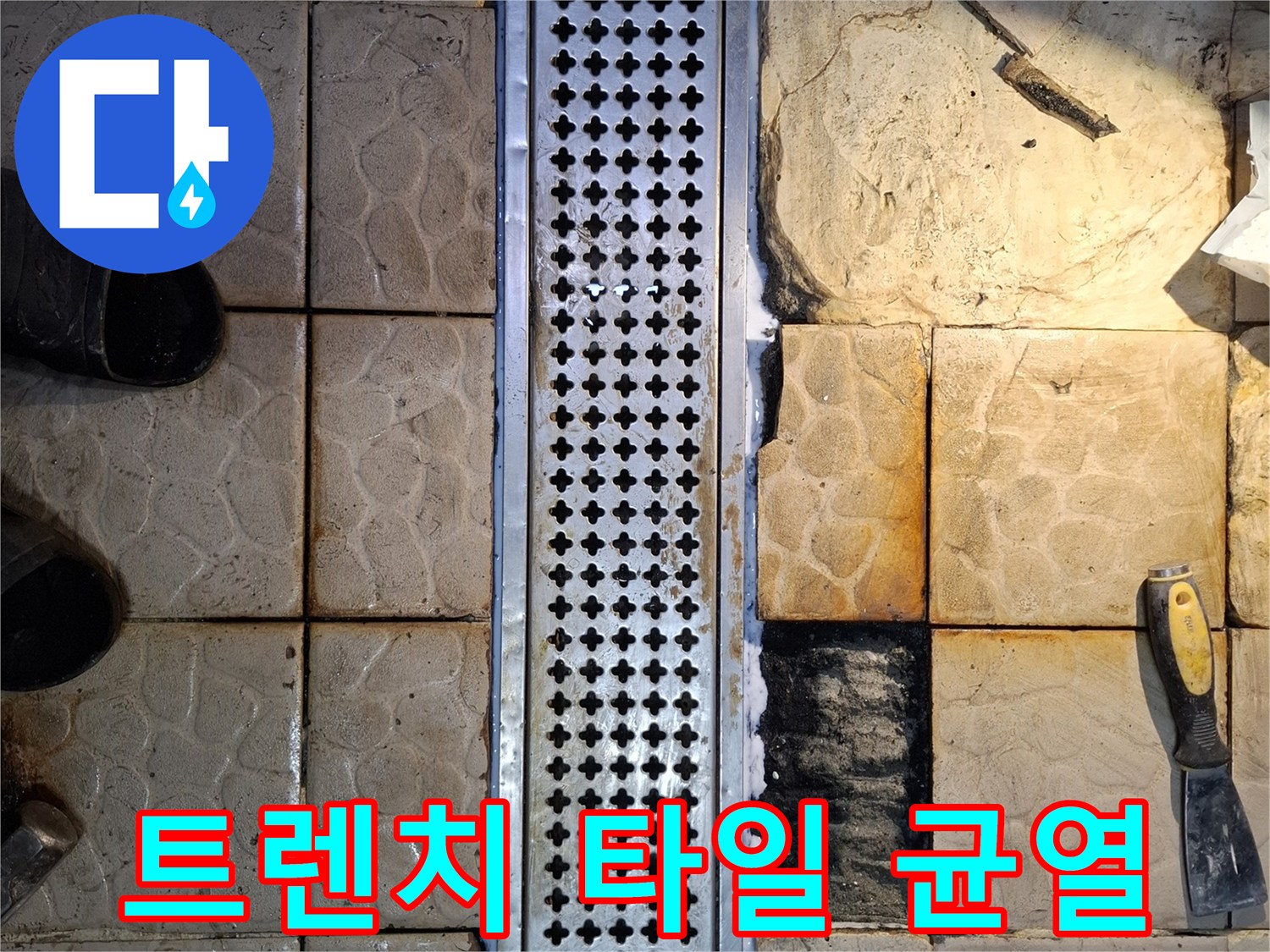 배수 트렌치와 맞닿은 젖은 타일의 벌어진 틈새