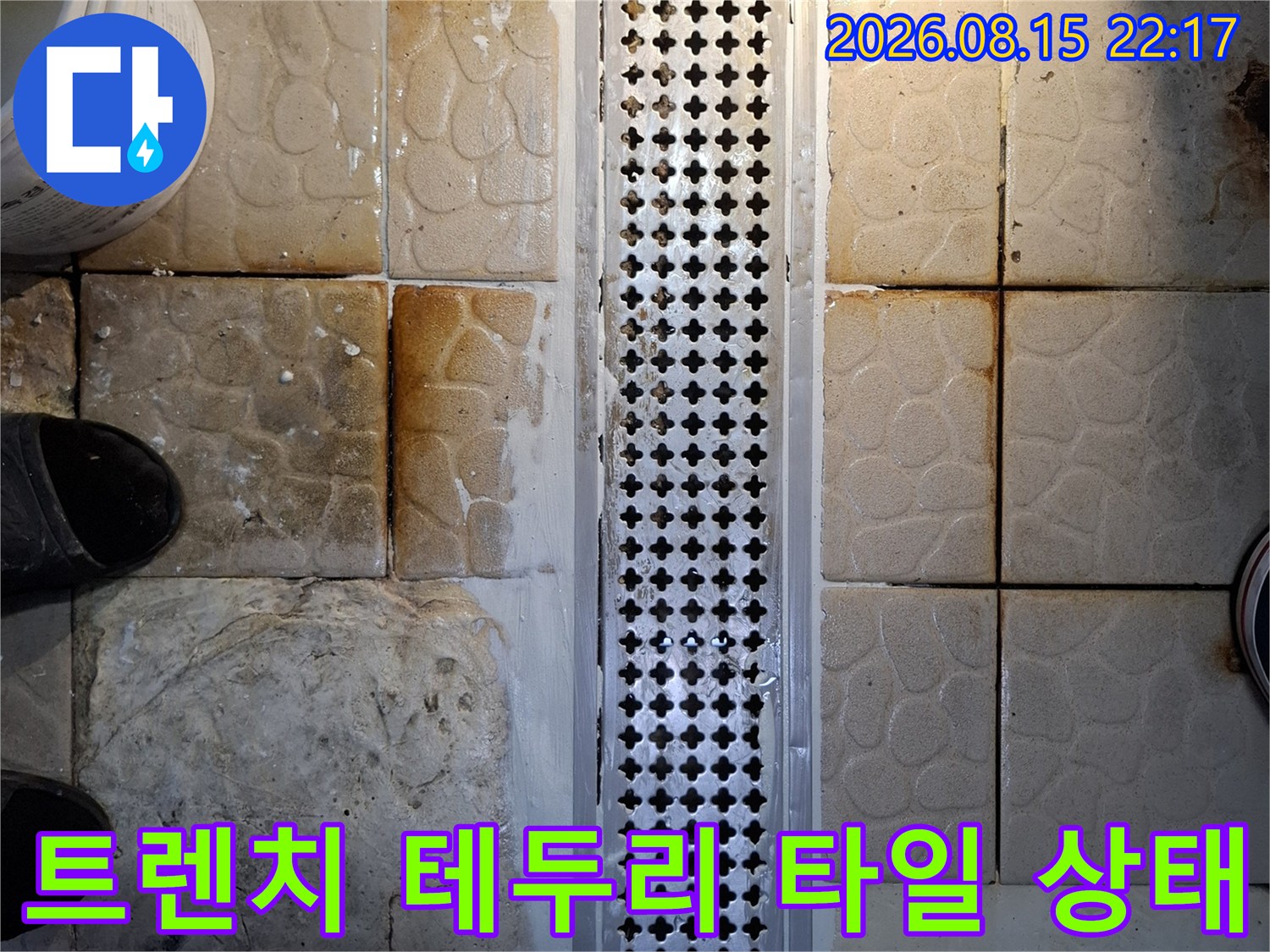 스테인리스 트렌치 주변의 젖은 타일과 틈새를 촬영했습니다.