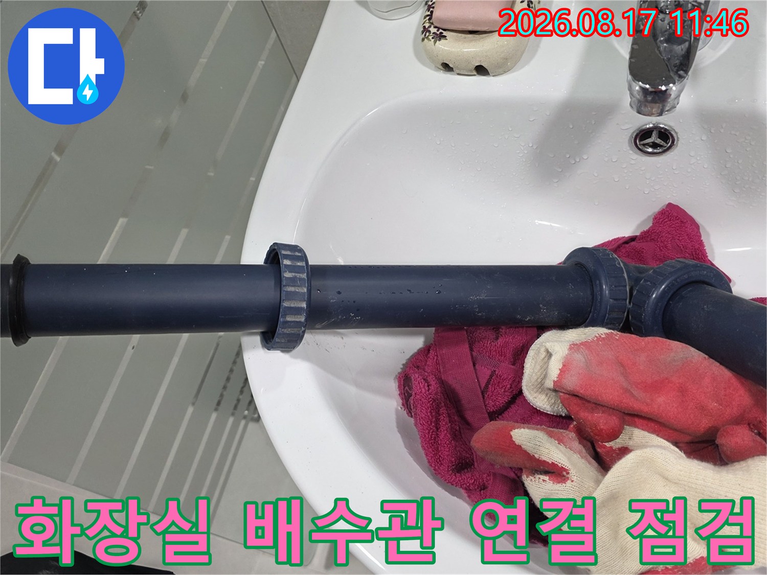 세면대 하부의 꺾인 배수 배관과 주변 장갑을 촬영한 사진입니다