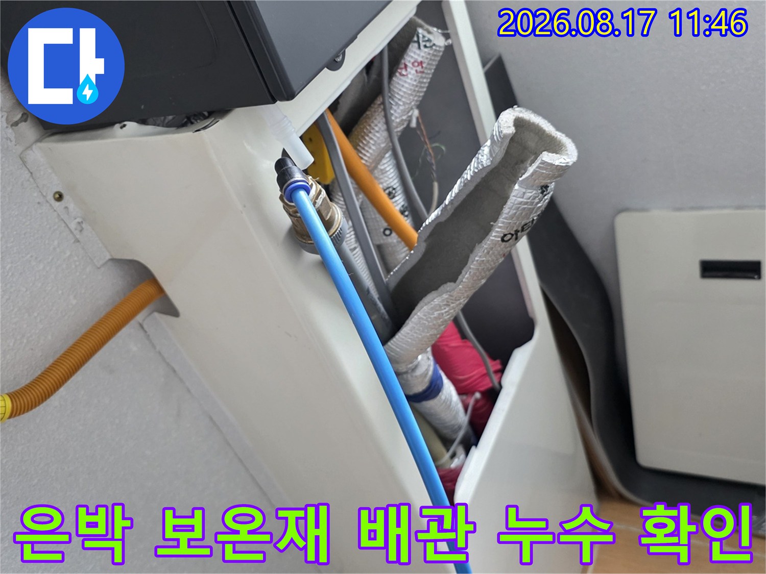 은박 보온재로 덮인 배관과 파란색 호스 주변의 습기 상태를 점검하는 장면
