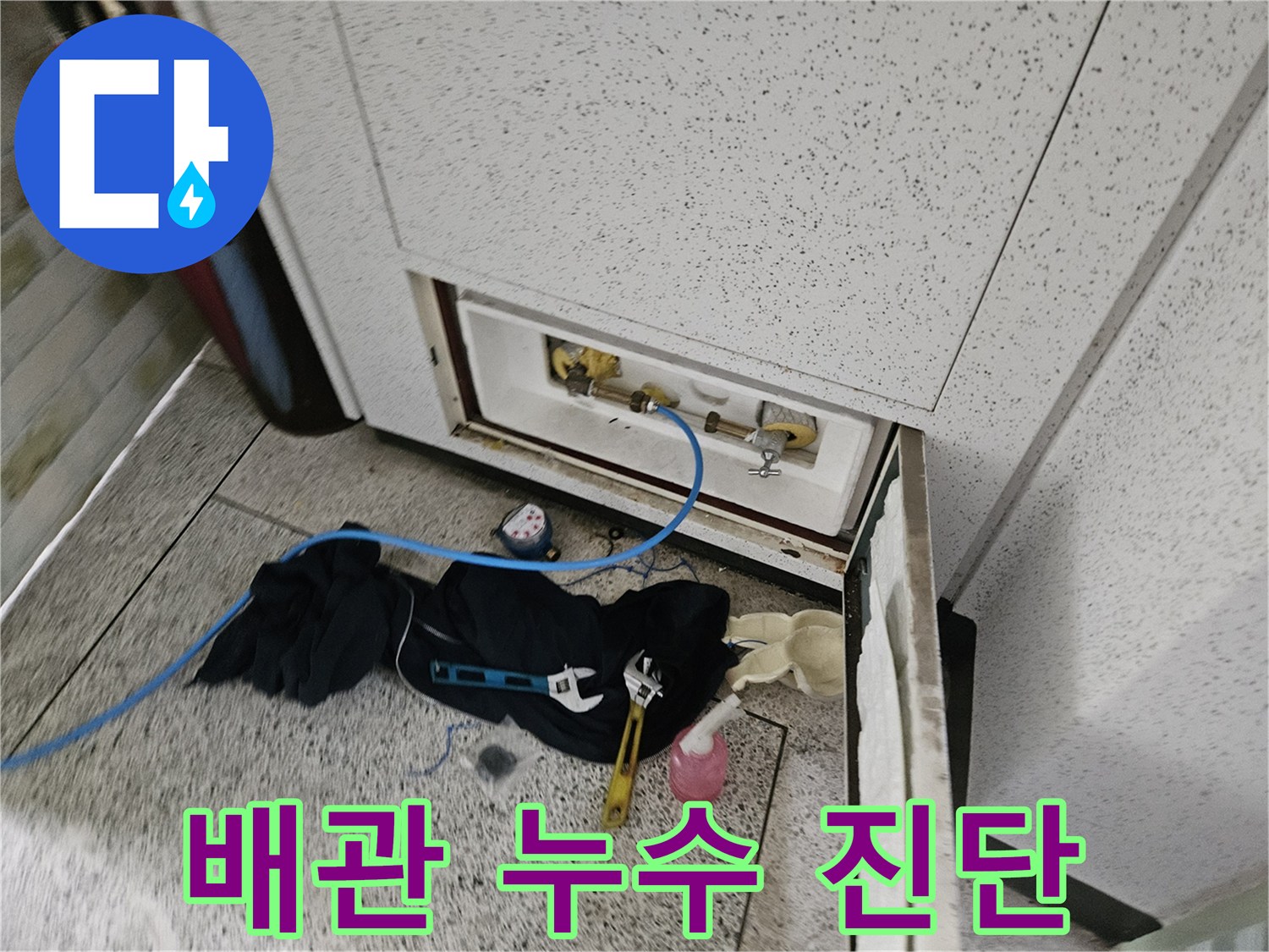 세면대 하부의 밸브와 배관 연결부를 정밀하게 조사하는 장면입니다.