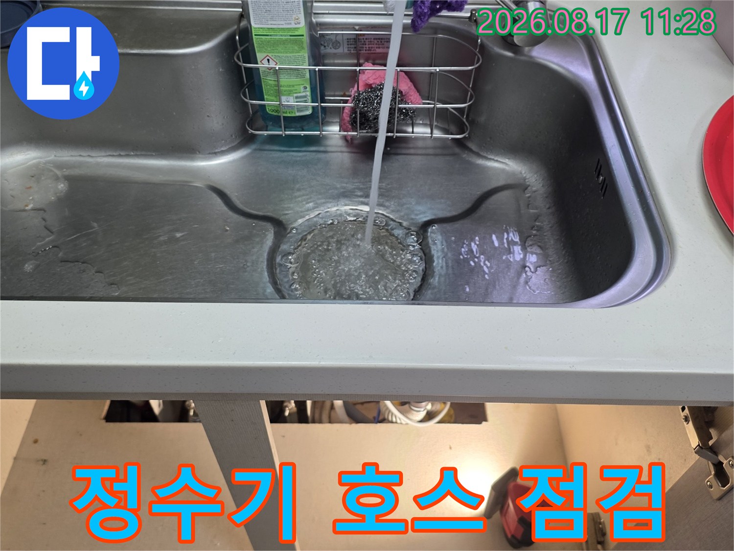 싱크대 아래 정수기 연결 부위와 배관의 누수 여부를 확인 중입니다