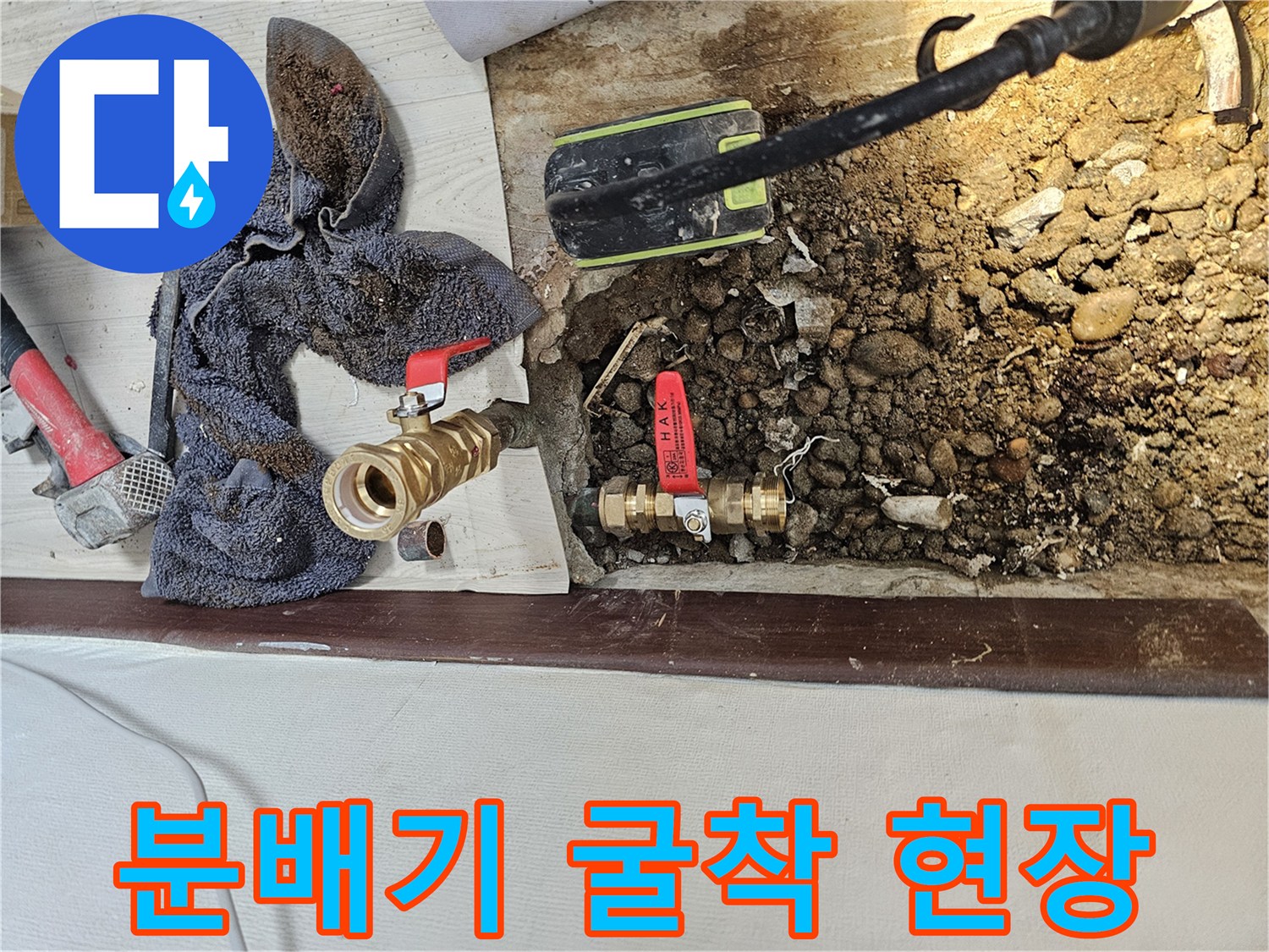 바닥을 걷어내고 드러난 누수 발생 분배기와 주변 공구들