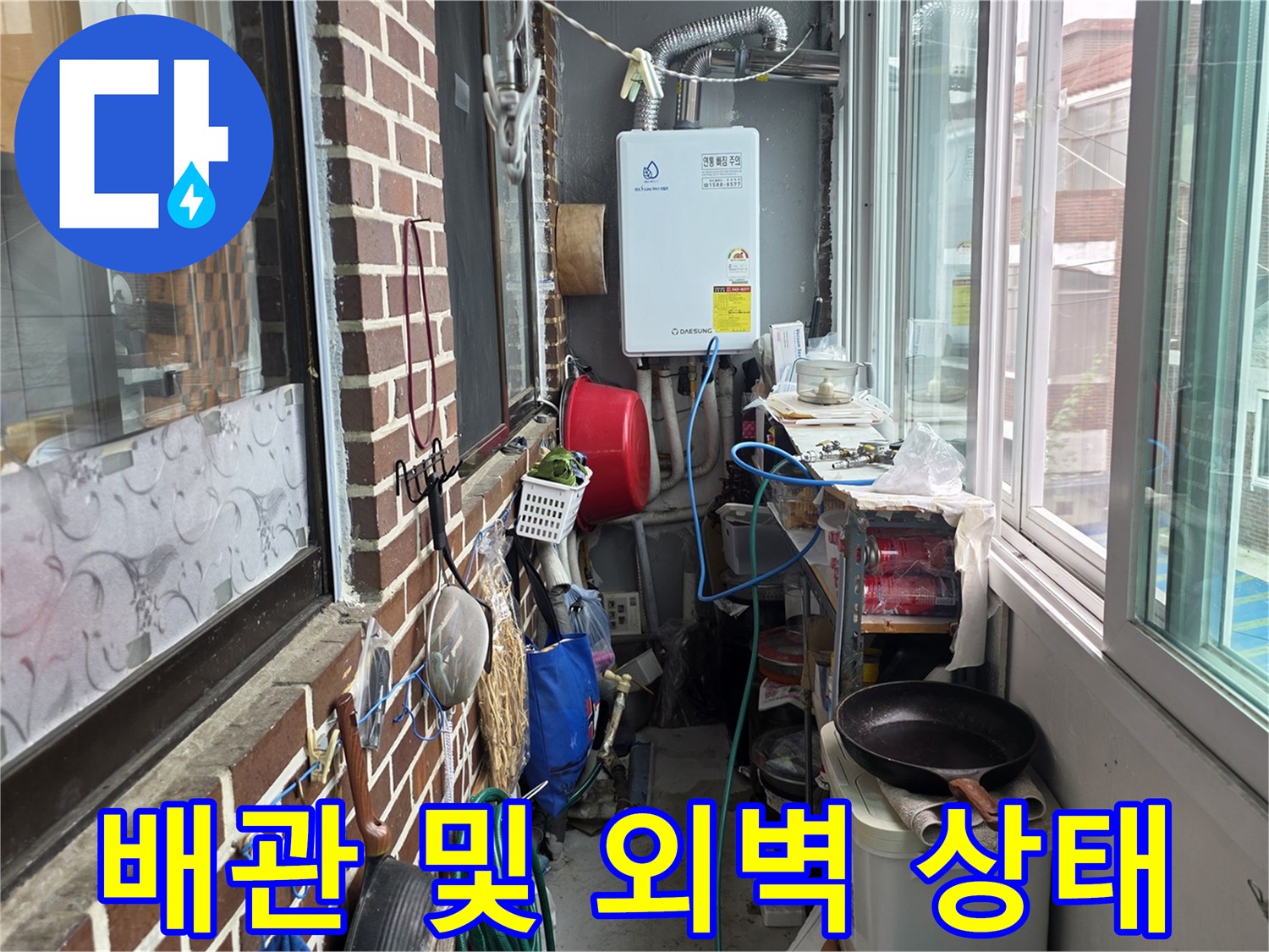 외부 노출된 보일러 배관과 벽돌 마감된 건물 외벽의 모습입니다.