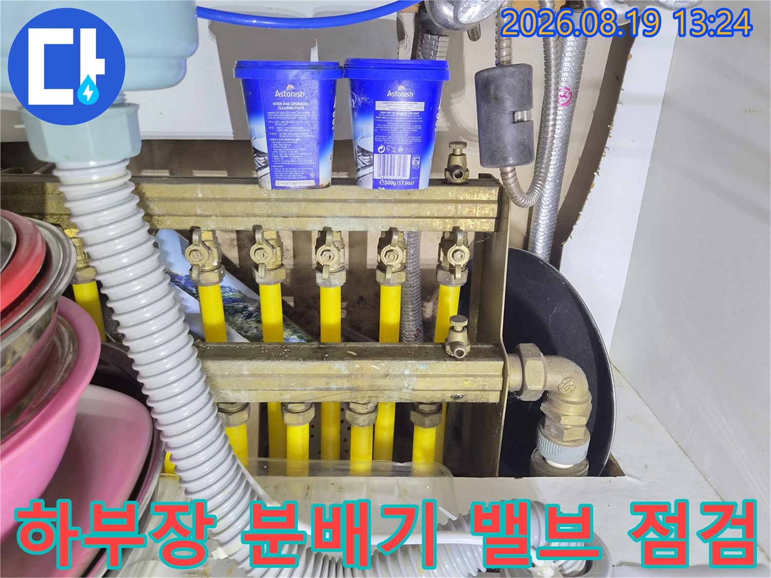 금속재질의 분배기 본체와 노란색 배관이 연결된 내부 모습입니다.