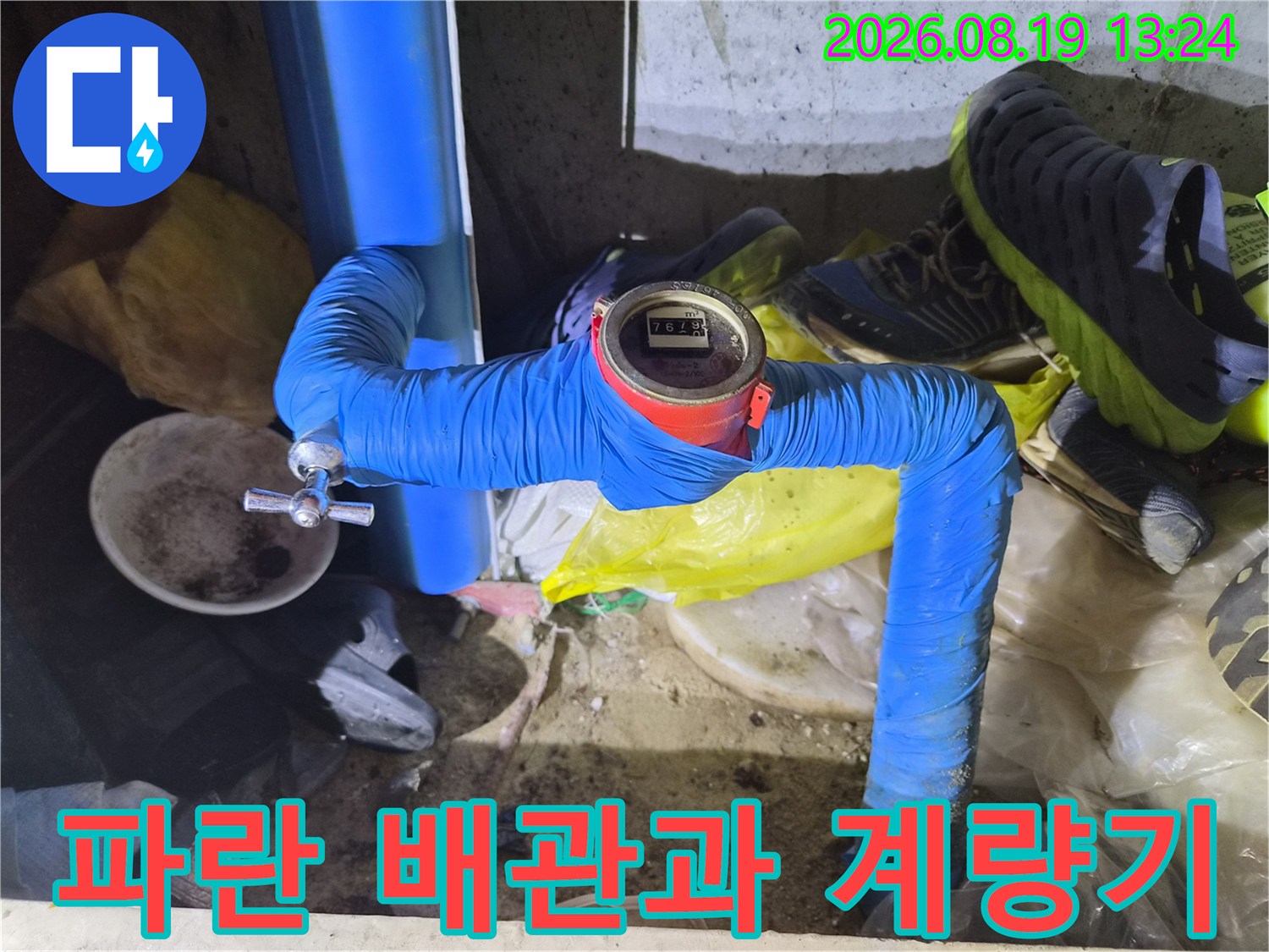 파란색 보온재로 감싸진 수도 배관과 디지털 수치가 표시된 계량기 모습입니다.