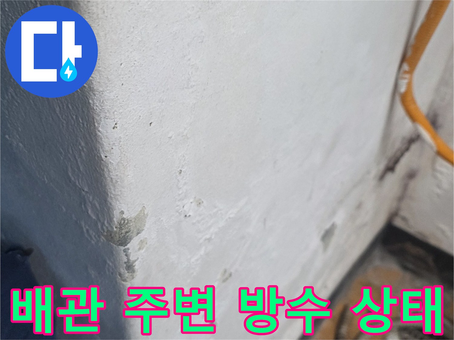 우수관 하부 마감재 표면에 나타난 습기 흔적과 얼룩을 촬영한 사진입니다.