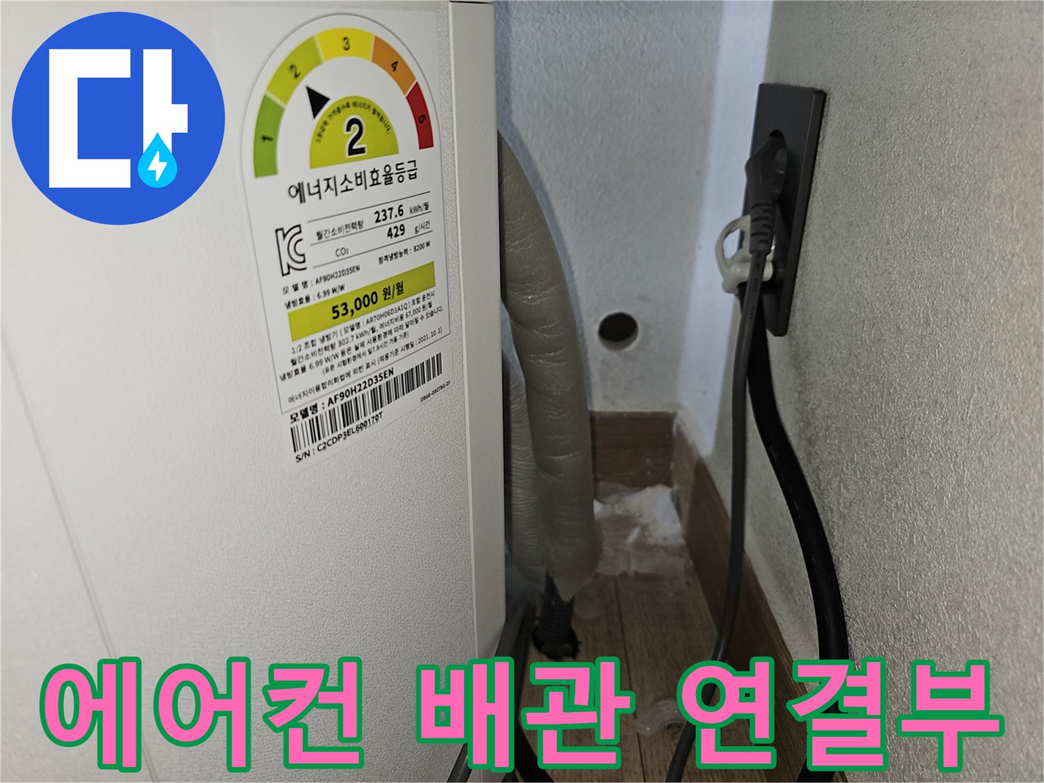벽면 콘센트 옆으로 지나가는 에어컨 배수 배관의 모습