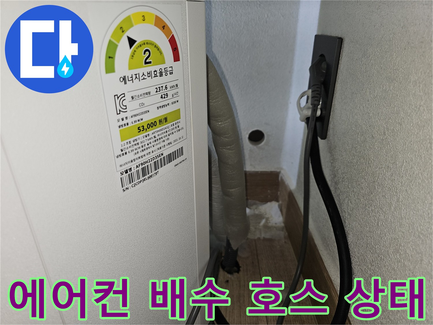 에어컨 본체 하단에 연결된 드레인 호스와 벽면 타공 부위 모습