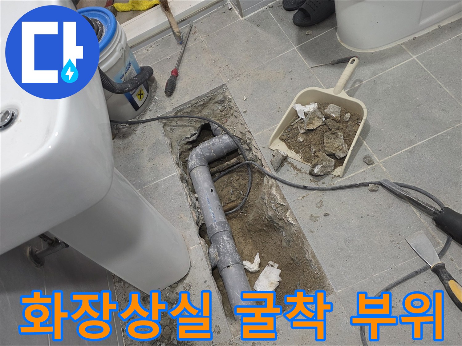 세면대 하단 타일 제거 후 드러난 배관 파손 및 작업용 삽과 도구들