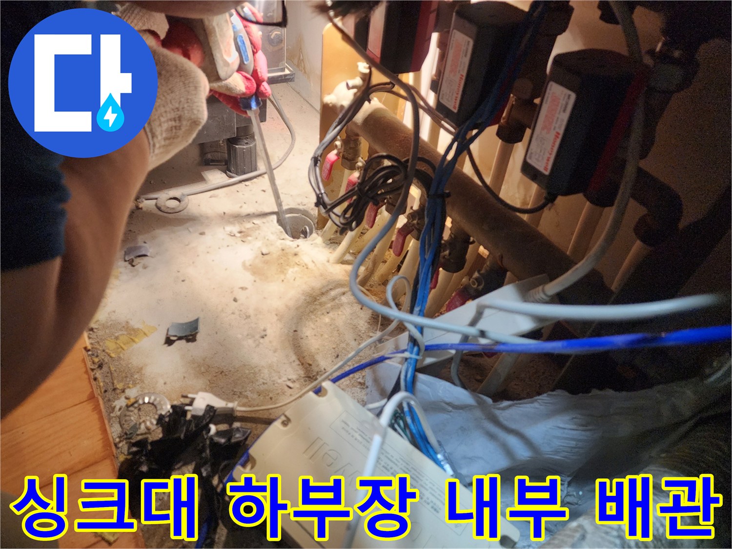 복잡하게 얽힌 싱크대 배관-배수구 역류 문제를 확인하기 위한 하부장 내부 모습입니다.