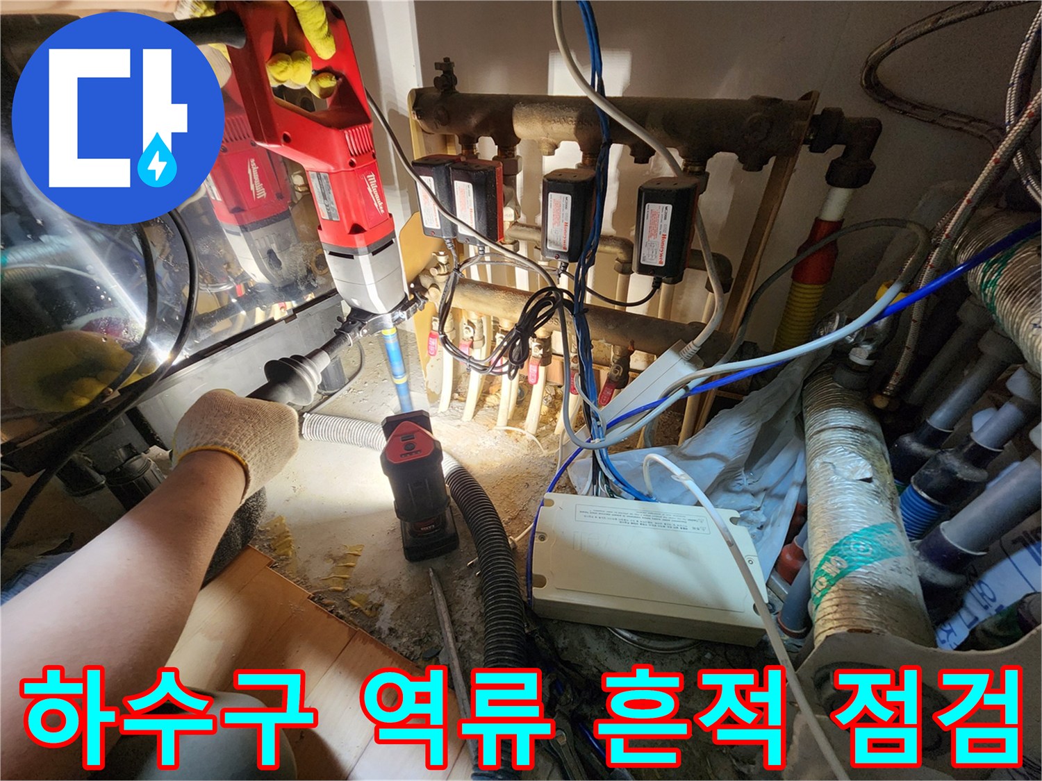 싱크대 하부 배관 주변의 오염된 상태와 작업용 장비가 배치된 모습