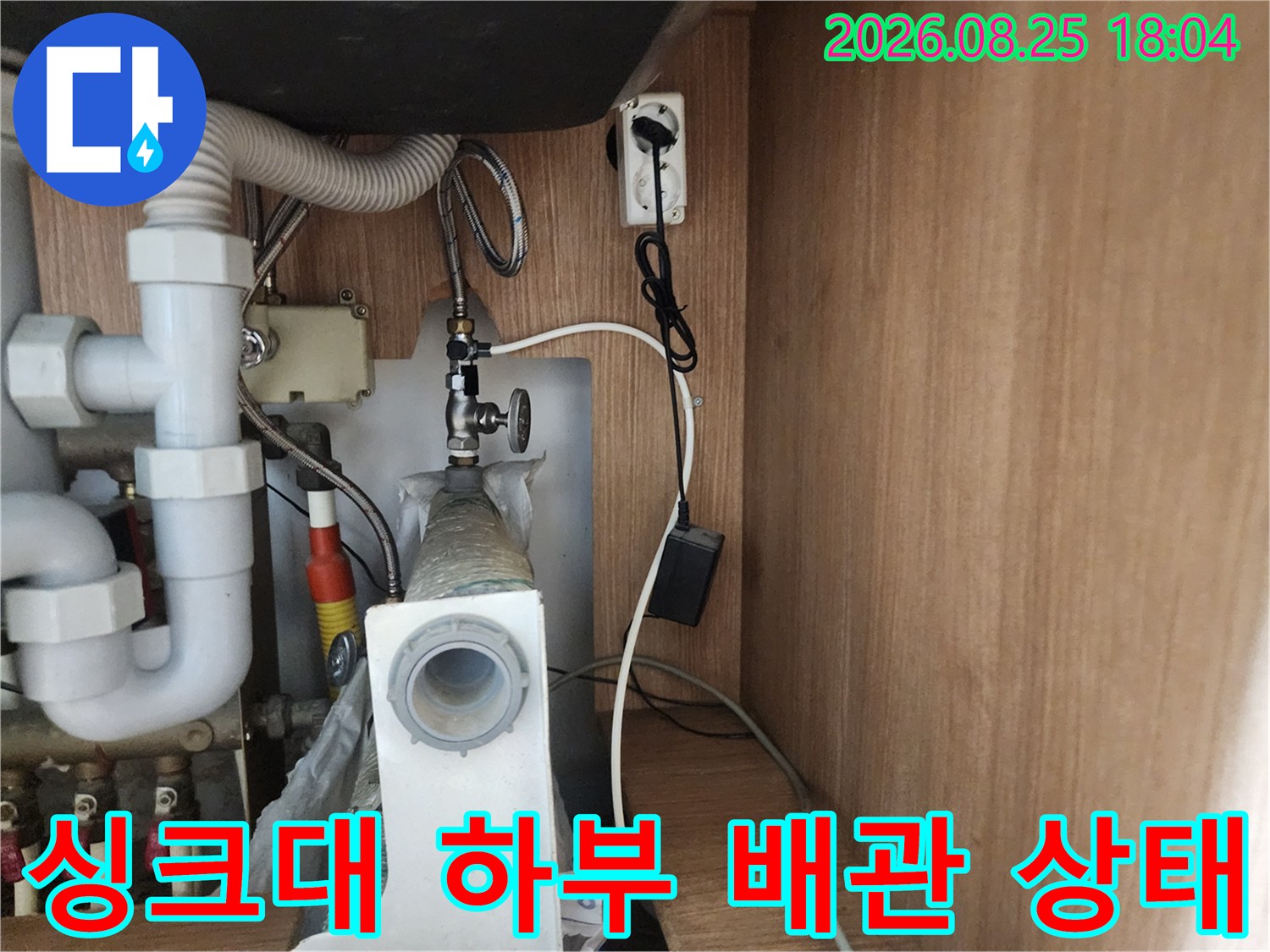 싱크대 하부장 내부의 배수관과 연결 부위 상태를 보여주는 사진입니다.