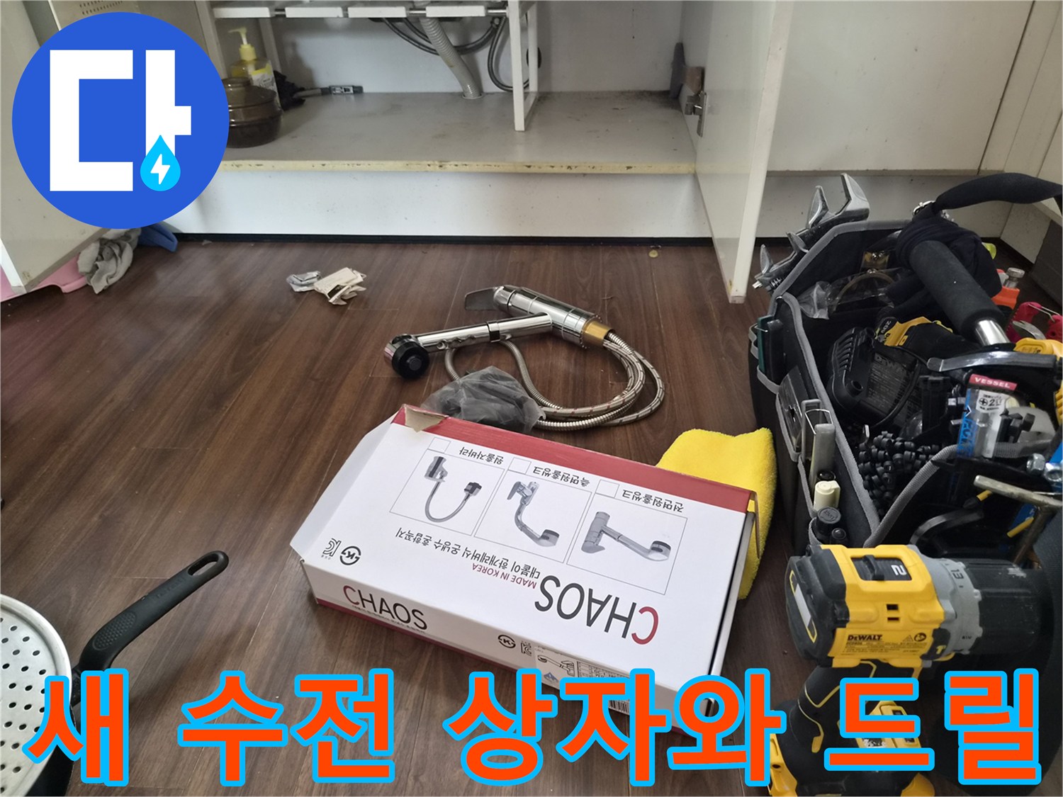 싱크대 밑에 놓여 있는 새 제품 박스와 작업용 전동 드릴