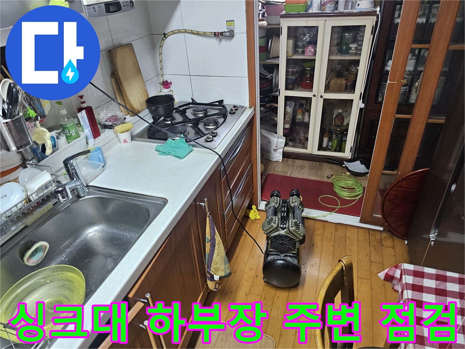 주방 수전과 가스 호스가 연결된 싱크대 내부 모습