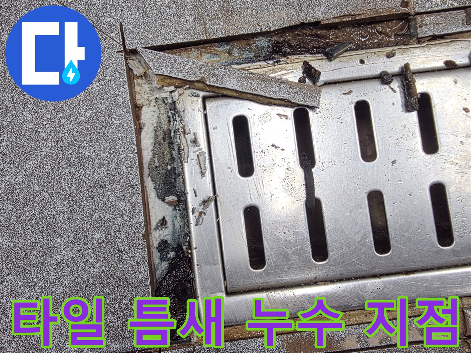 배수구 주변의 벌어진 타일 틈새를 근접 촬영한 사진입니다.