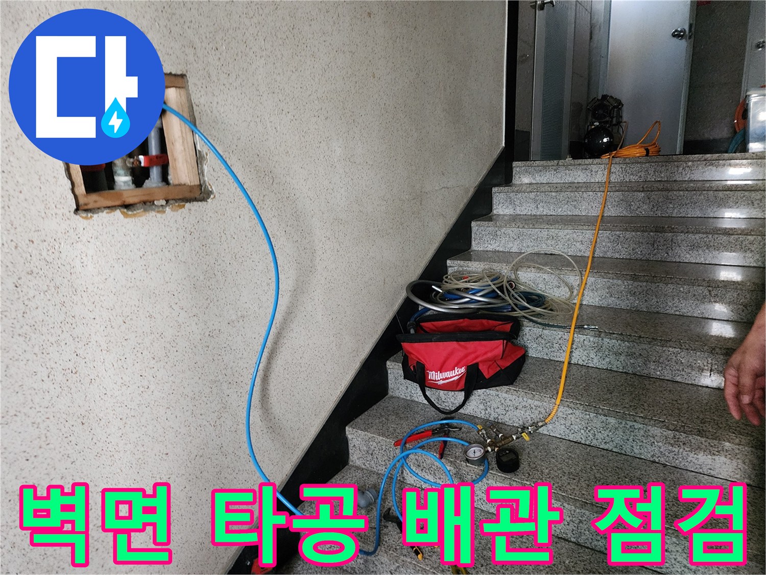 화장실 벽면을 타공하여 내부 배관 상태를 확인하는 모습