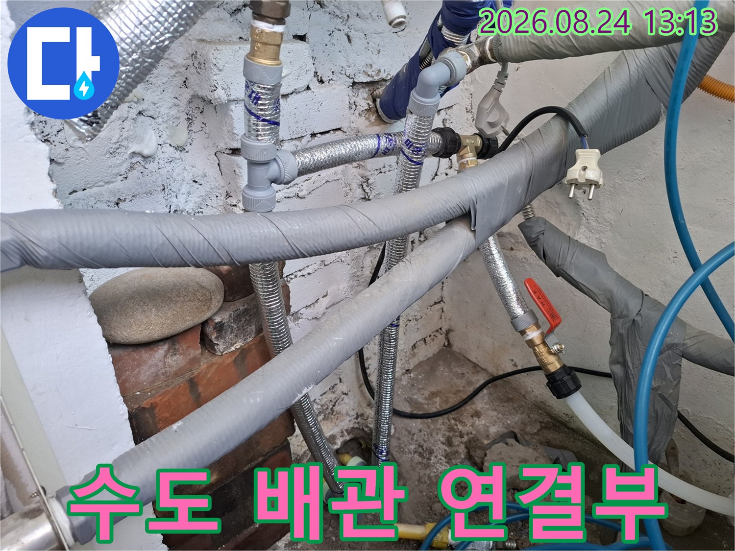 은박 테이프로 마감된 수도 배관과 밸브 장치를 상세히 촬영하였습니다.