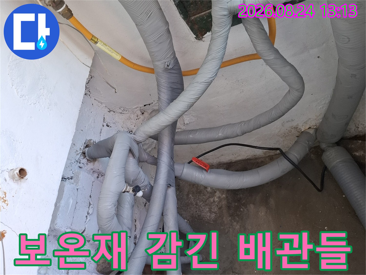 회색 보온재로 덮여 있는 복잡한 구조의 배관 시스템