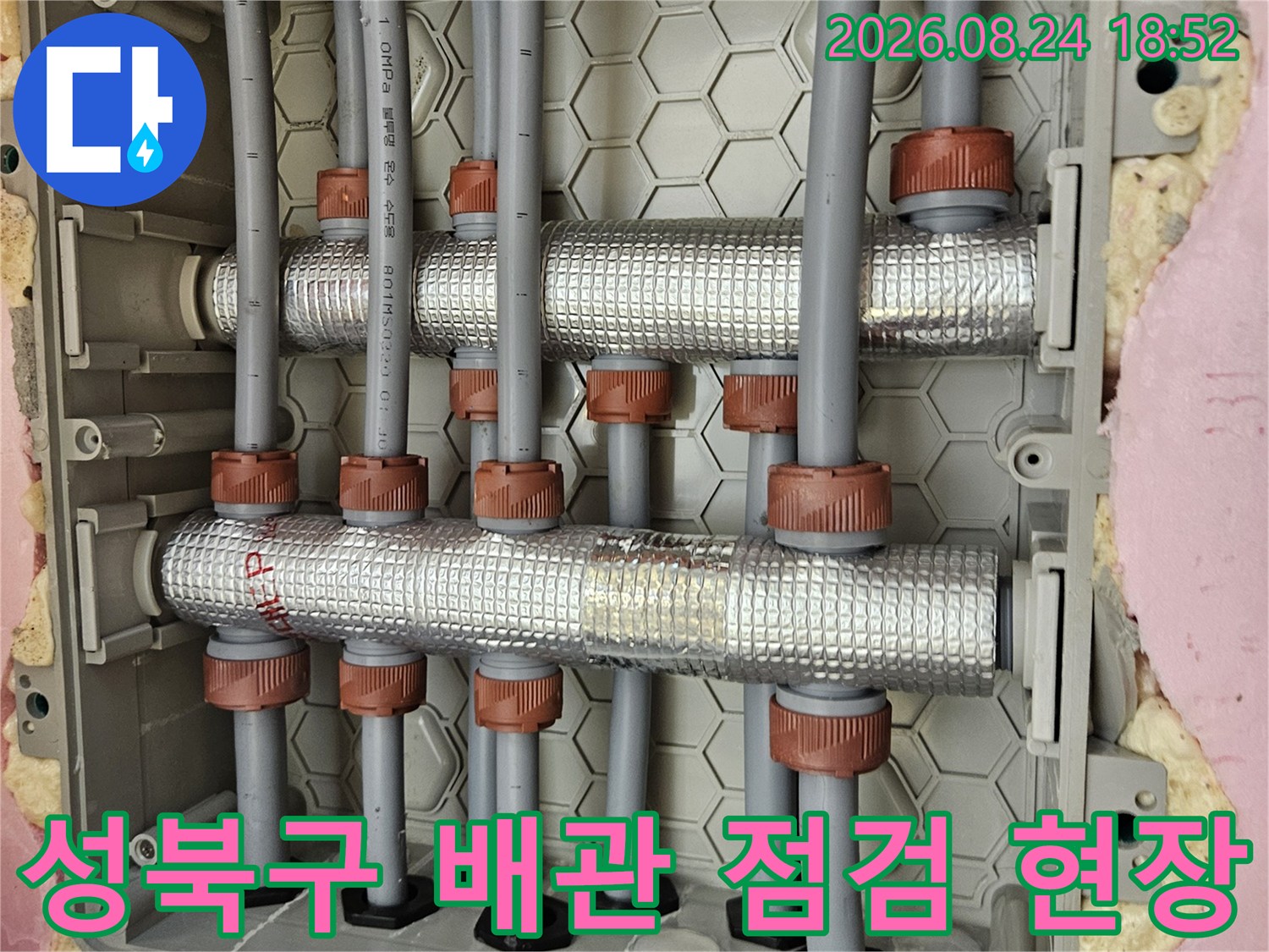 성북구 장위동-화장실 천장 내부의 수전 분배기 및 보온재로 감싸진 배관 상태를 확인하는 모습입니다.