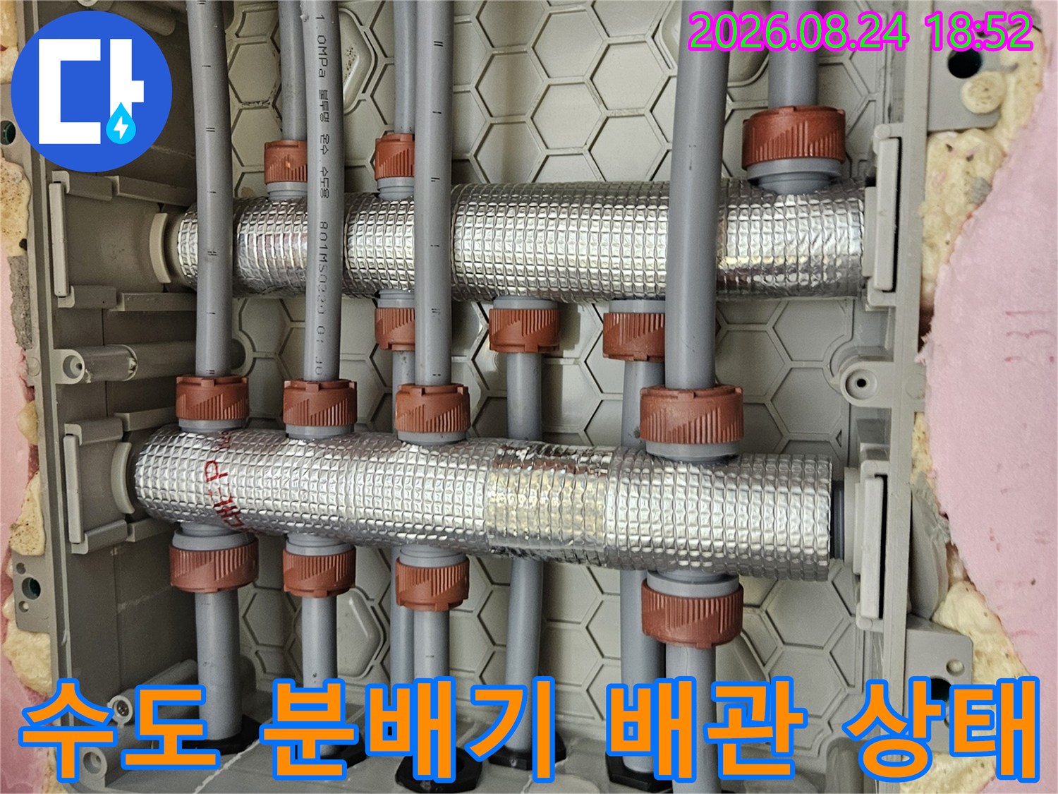 은박 보온재로 마감된 - 수전 분배기와 연결 배관의 상세 모습