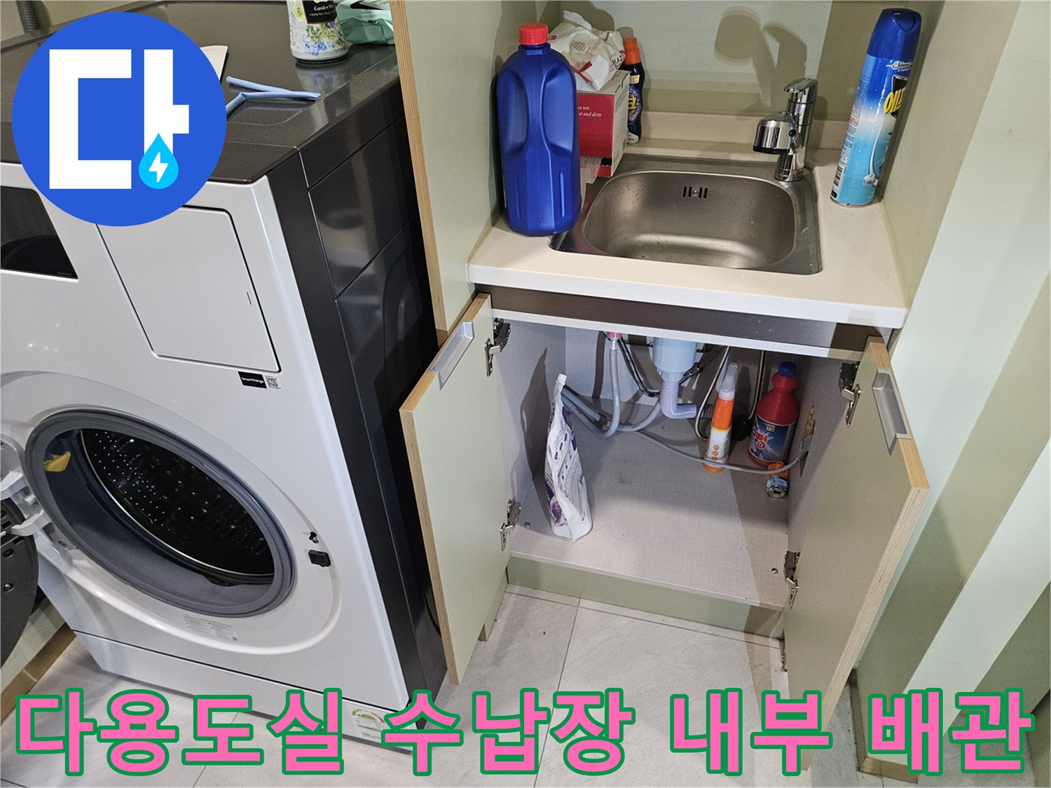 세탁기 옆 수납 공간 내부에 배치된 배관과 세제 통들
