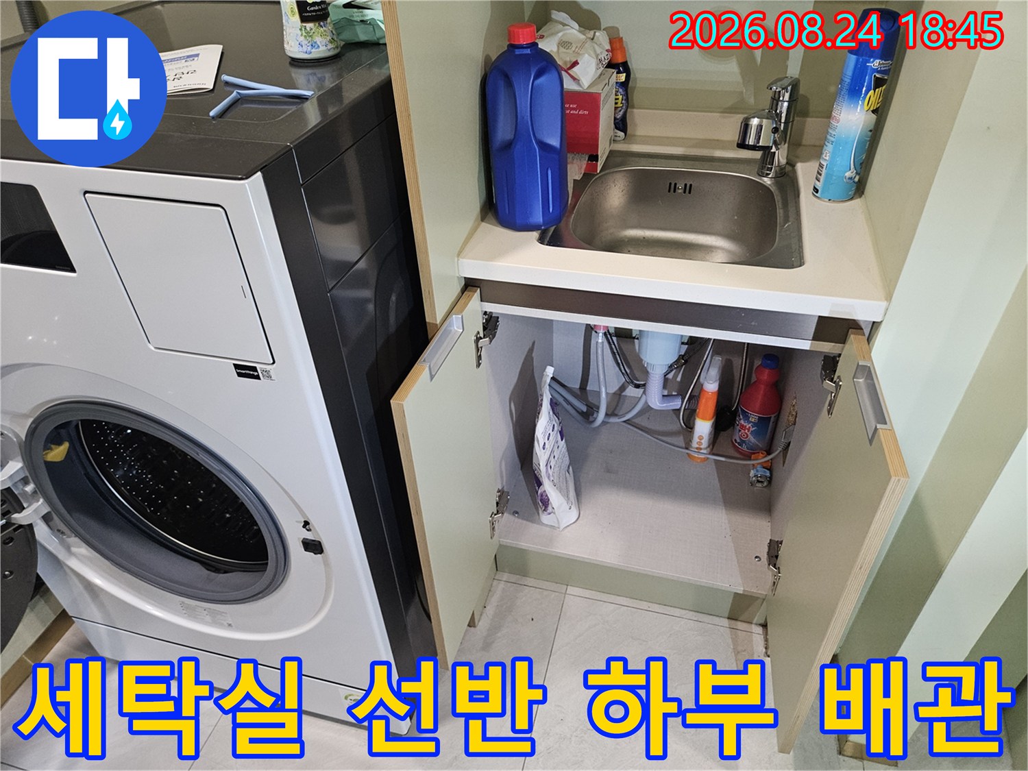 세탁기 옆 수납 공간 내의 배관 및 세탁 용품 모습