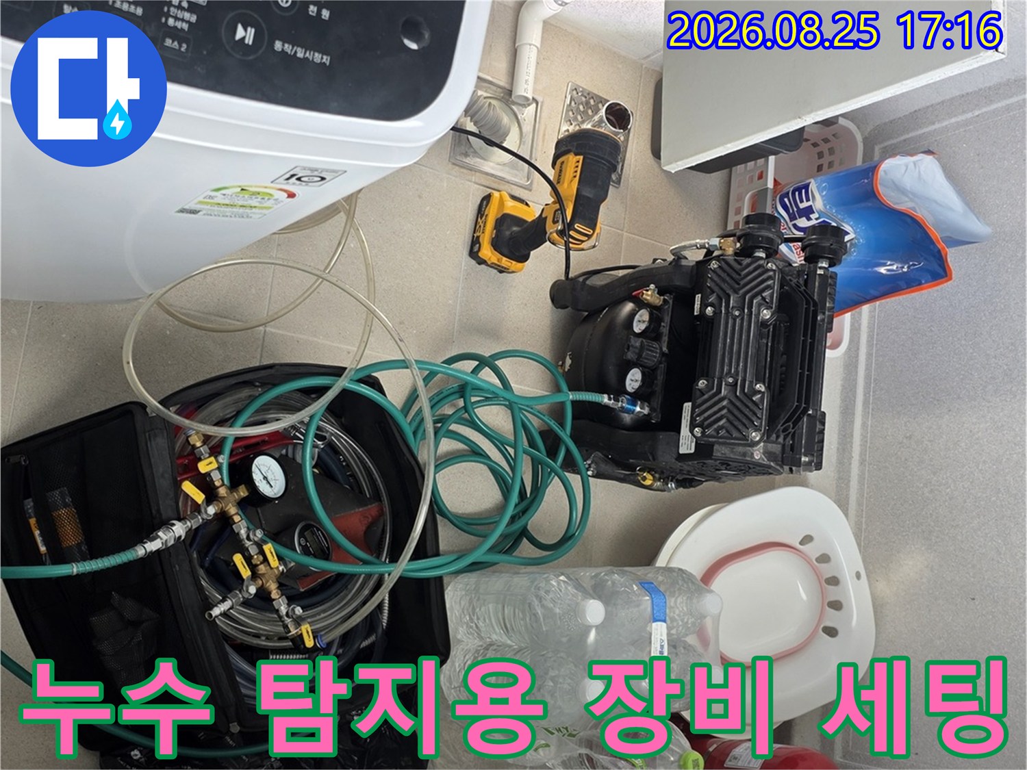 세탁실 바닥에 놓인 배관 점검 장비와 각종 수리용 자재 및 도구들