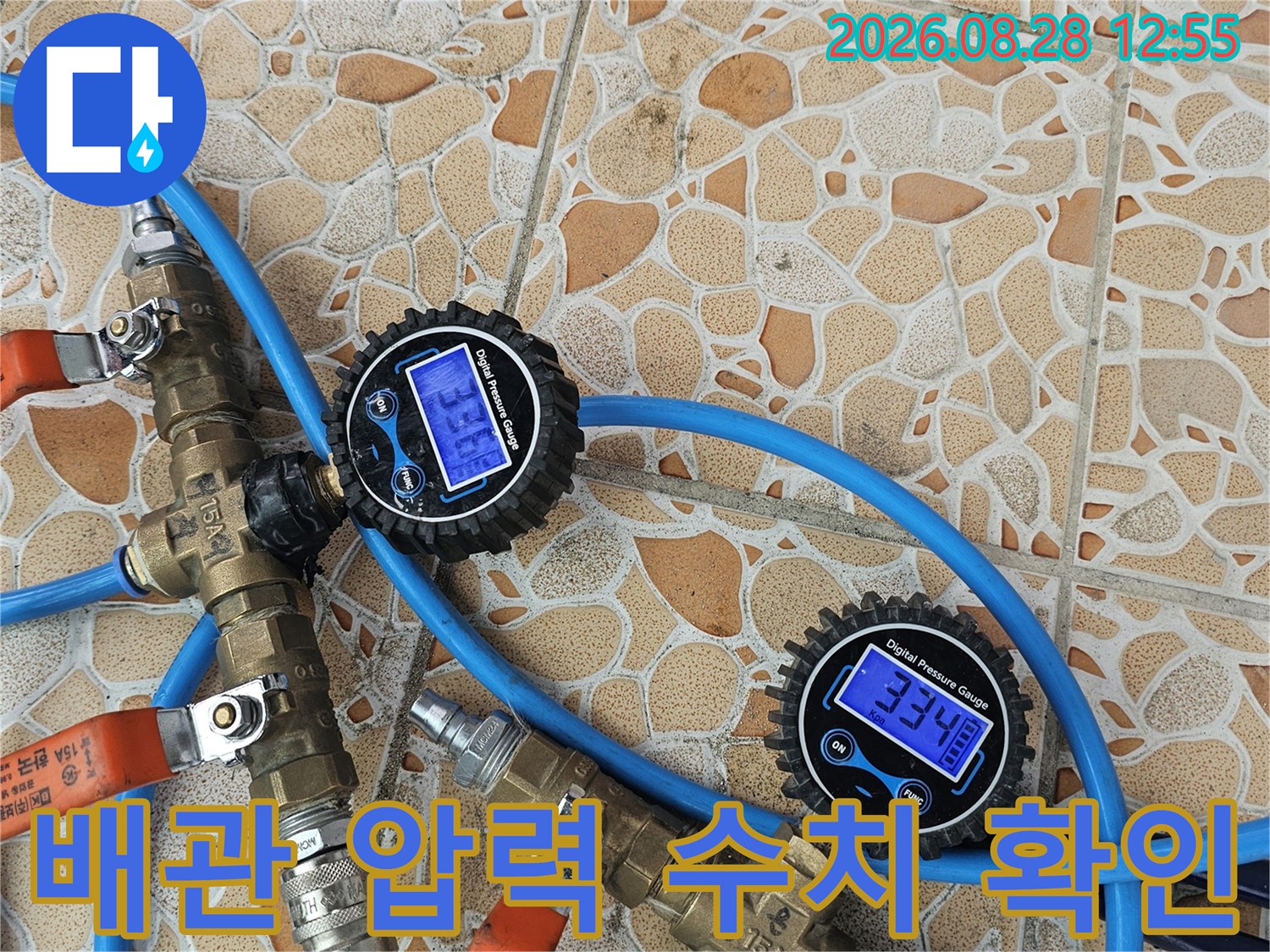 파란색 호스와 연결된 배관 공압 테스트 장비와 디지털 게이지