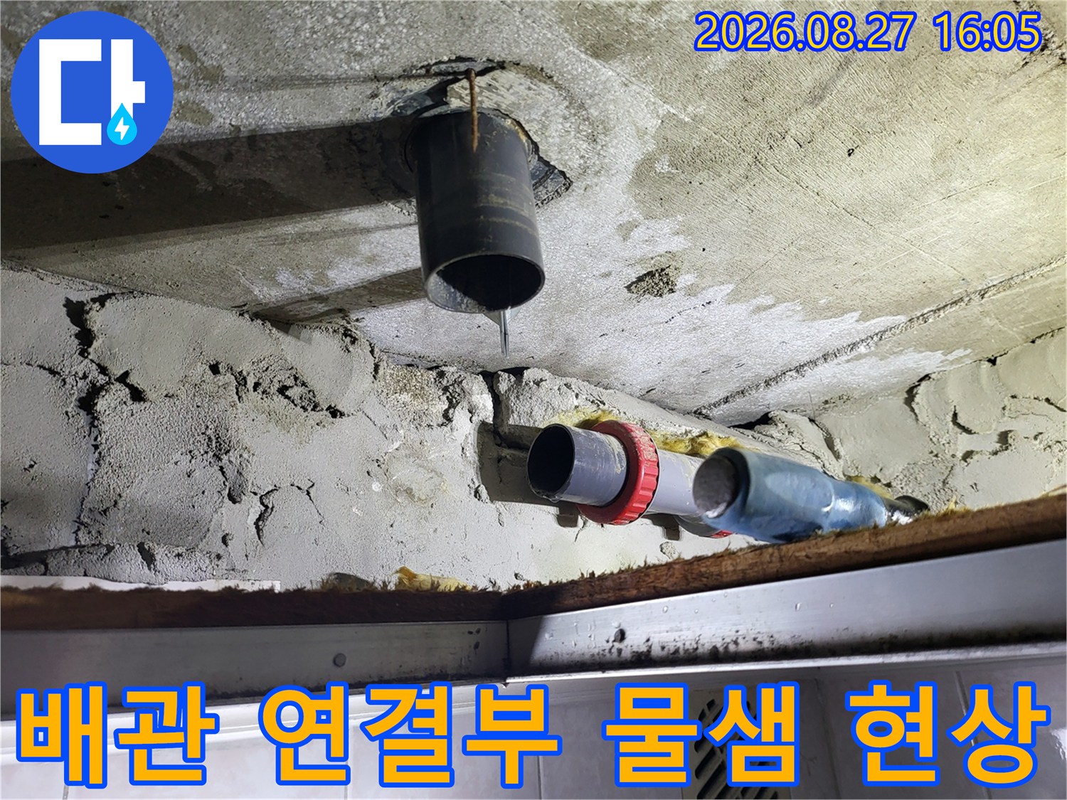 천장 배관 사이로 물이 떨어지며 주변 콘크리트가 젖어 있는 장면