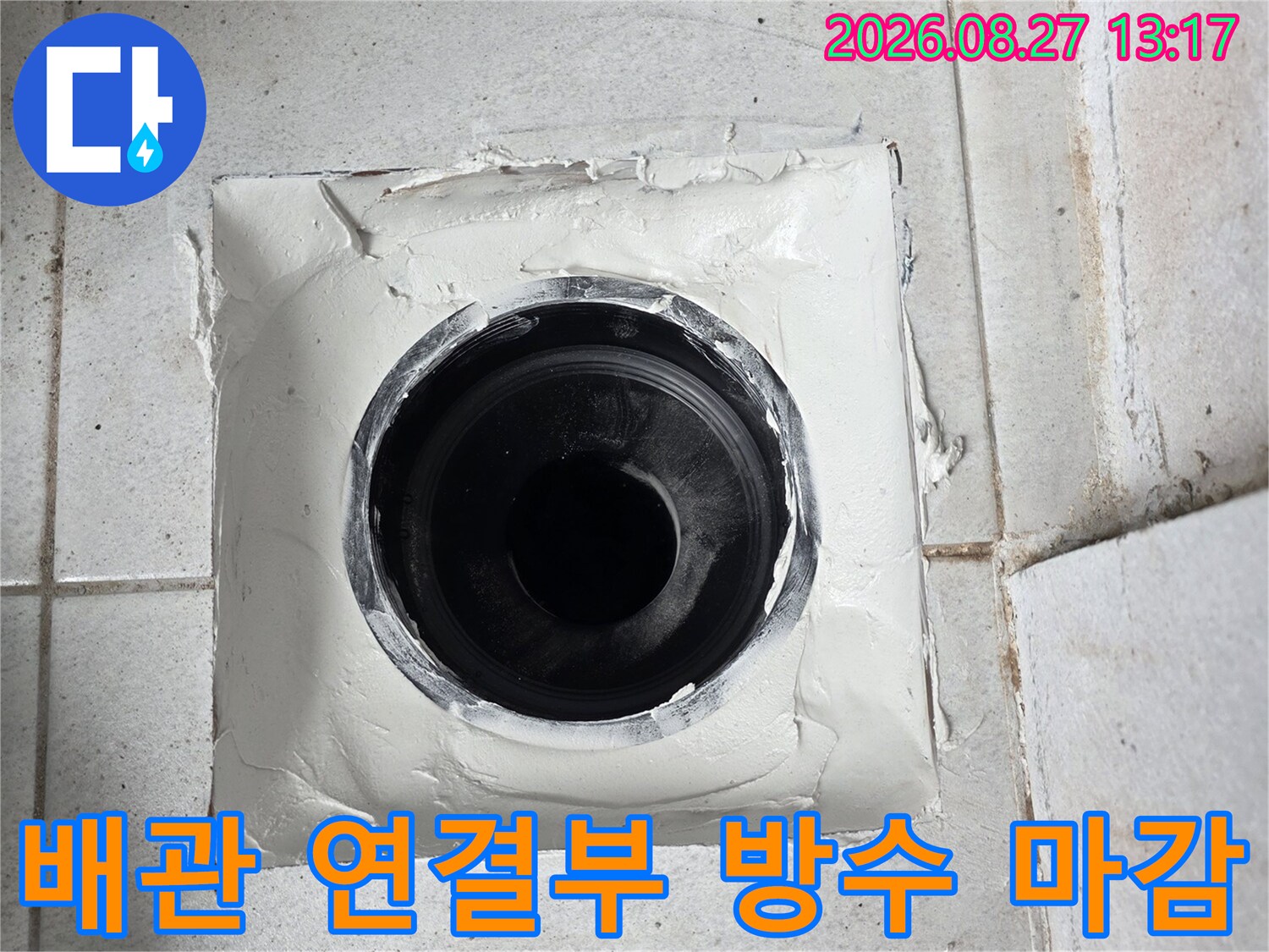 검은색 우수관 주변을 하얀색 실링재로 두껍게 감싸 누수를 차단한 사진입니다.