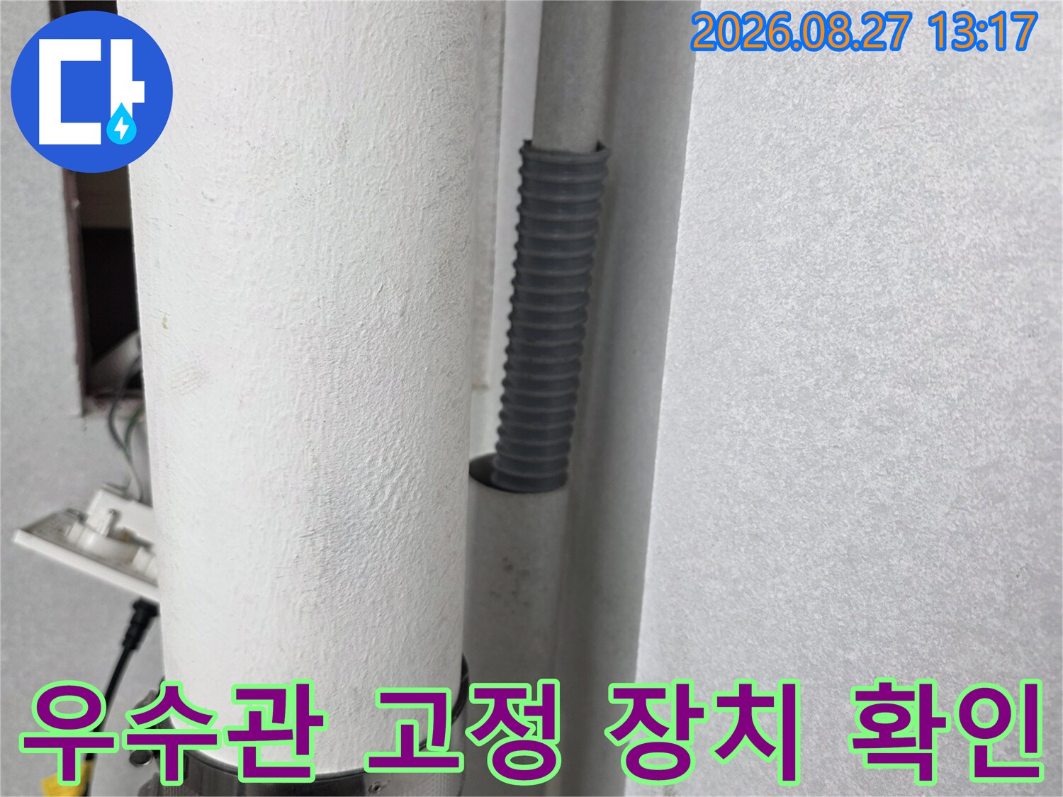 금속 밴드로 조여진 우수관의 연결 및 고정 모습입니다.
