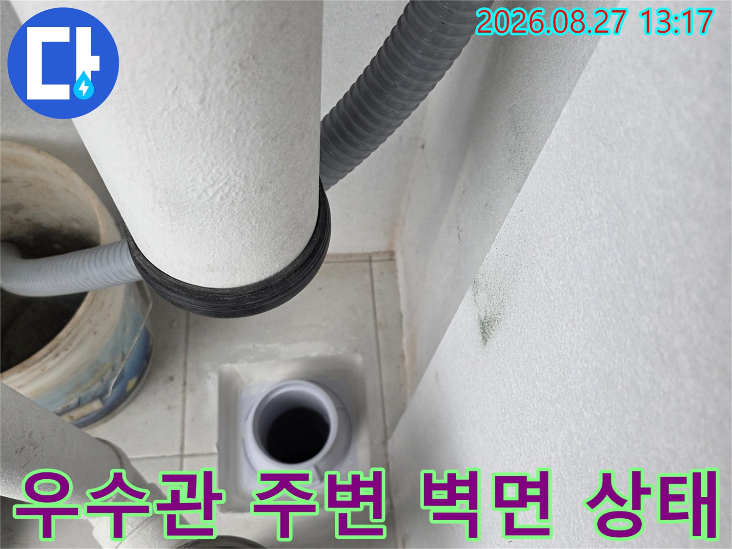 우수관이 통과하는 벽면과 배관 연결 부위의 근접 촬영 사진입니다.