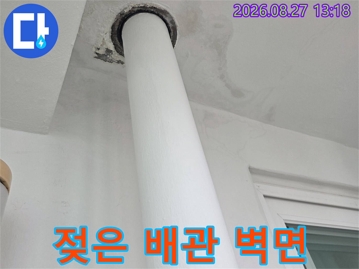 하얀색 우수관 배관 주변에 발생한 젖은 얼룩과 벽지 변색