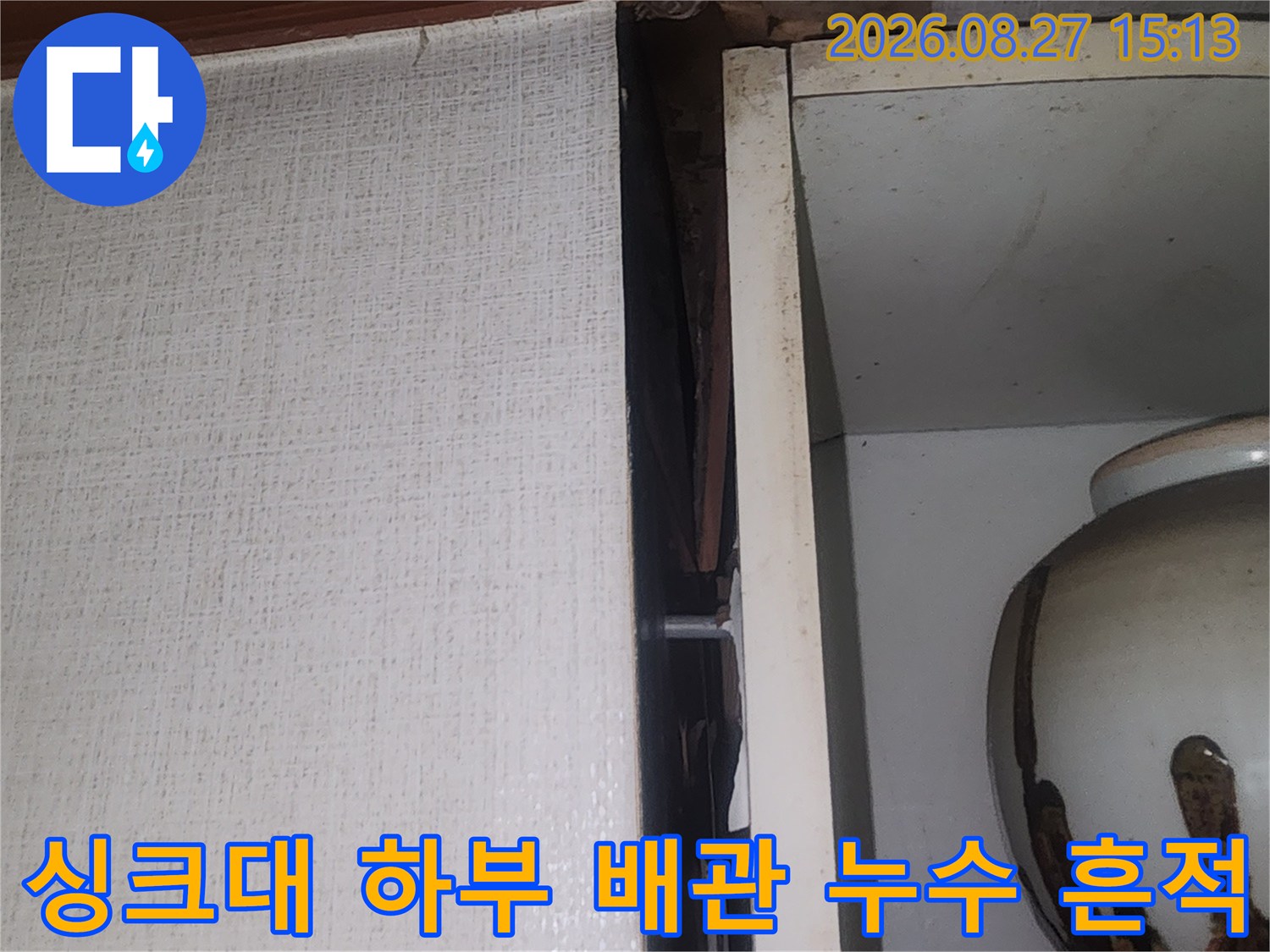 싱크대 아래쪽 벽면에 나타난 물자국과 오염된 마감재