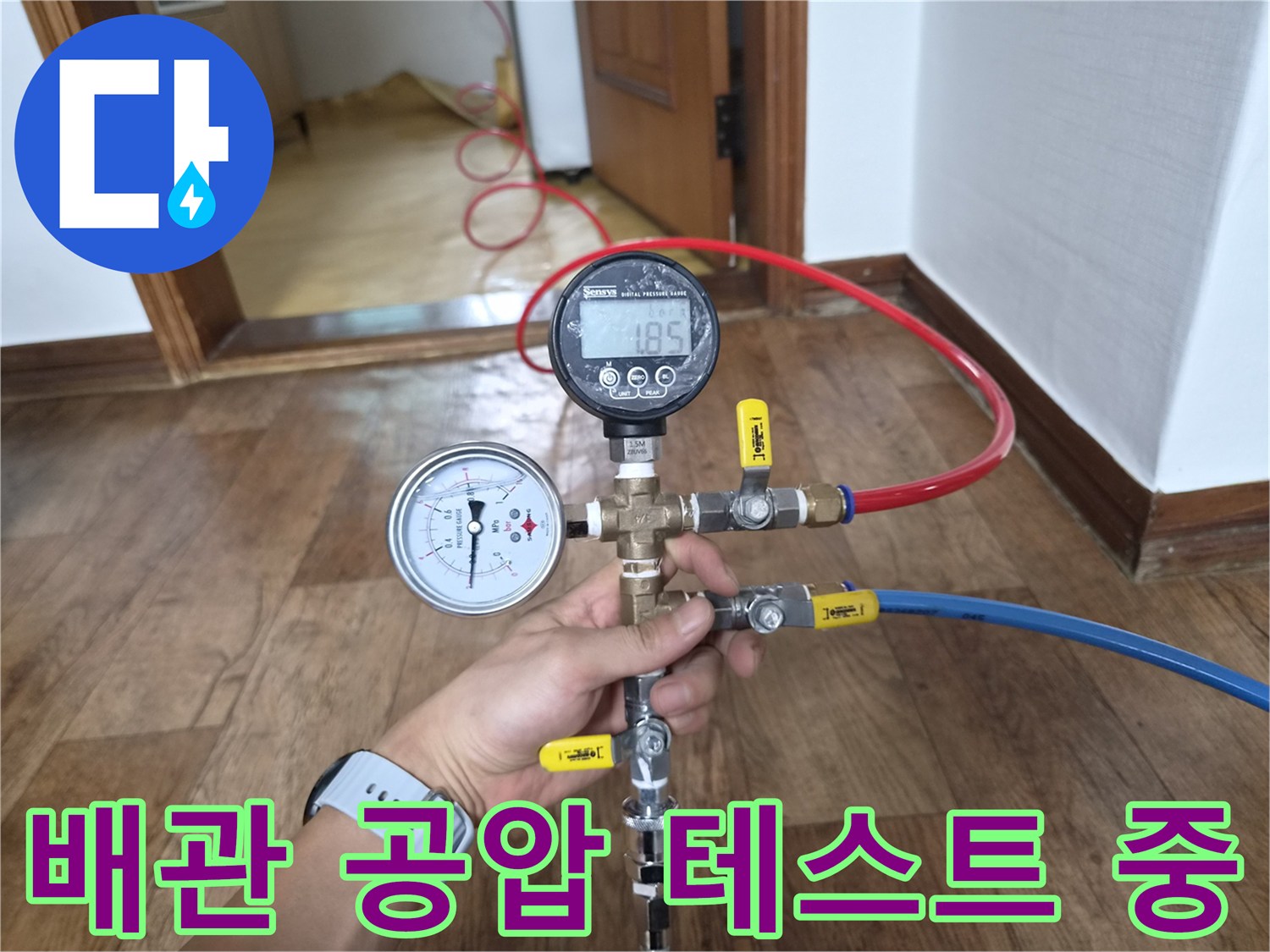 배관 연결 부위에 압력 게이지를 설치하여 누설 여부를 정밀하게 측정하는 장면입니다.