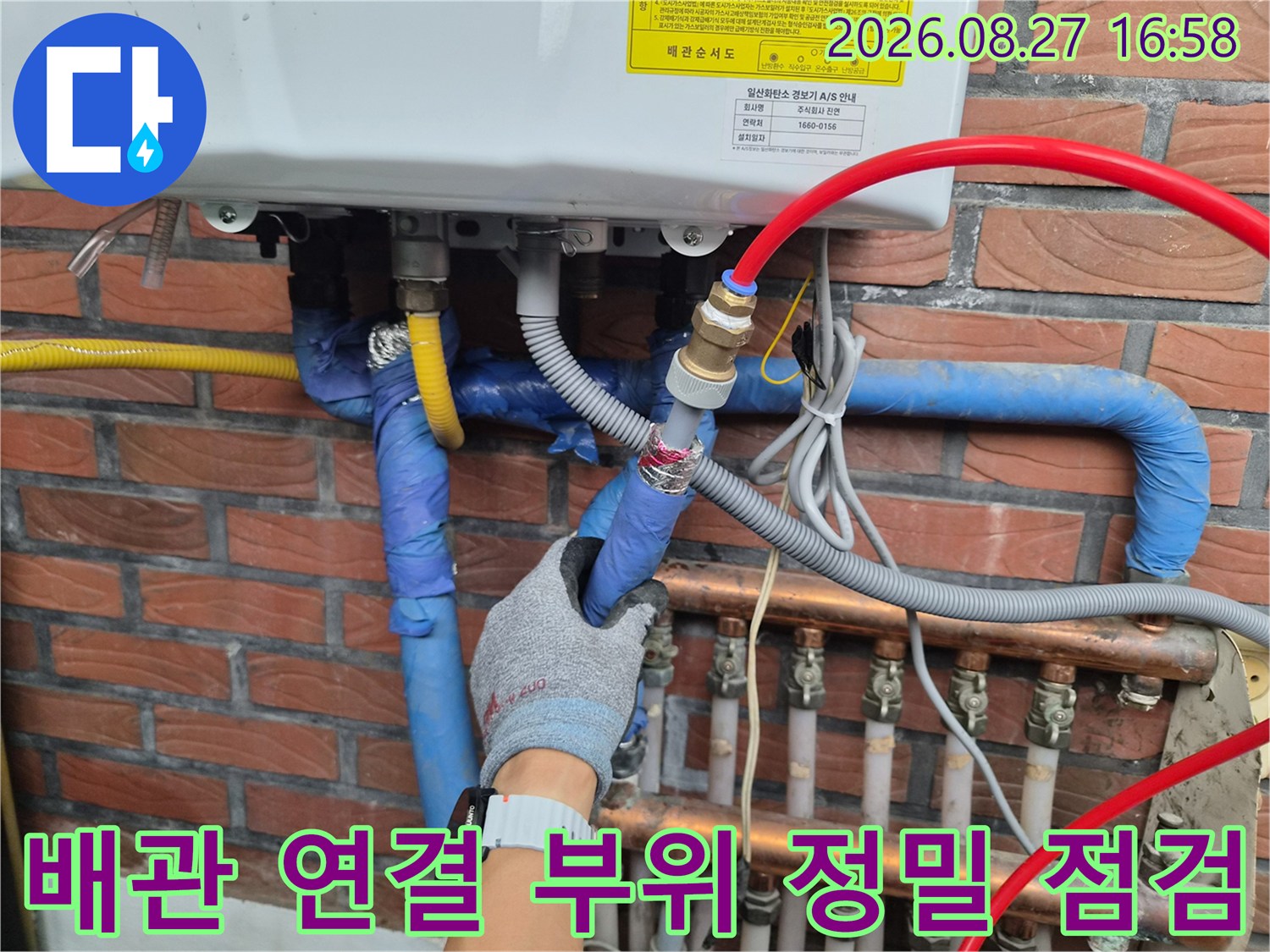 장갑을 낀 작업자가 보일러 배관의 금속 연결부를 만지는 장면