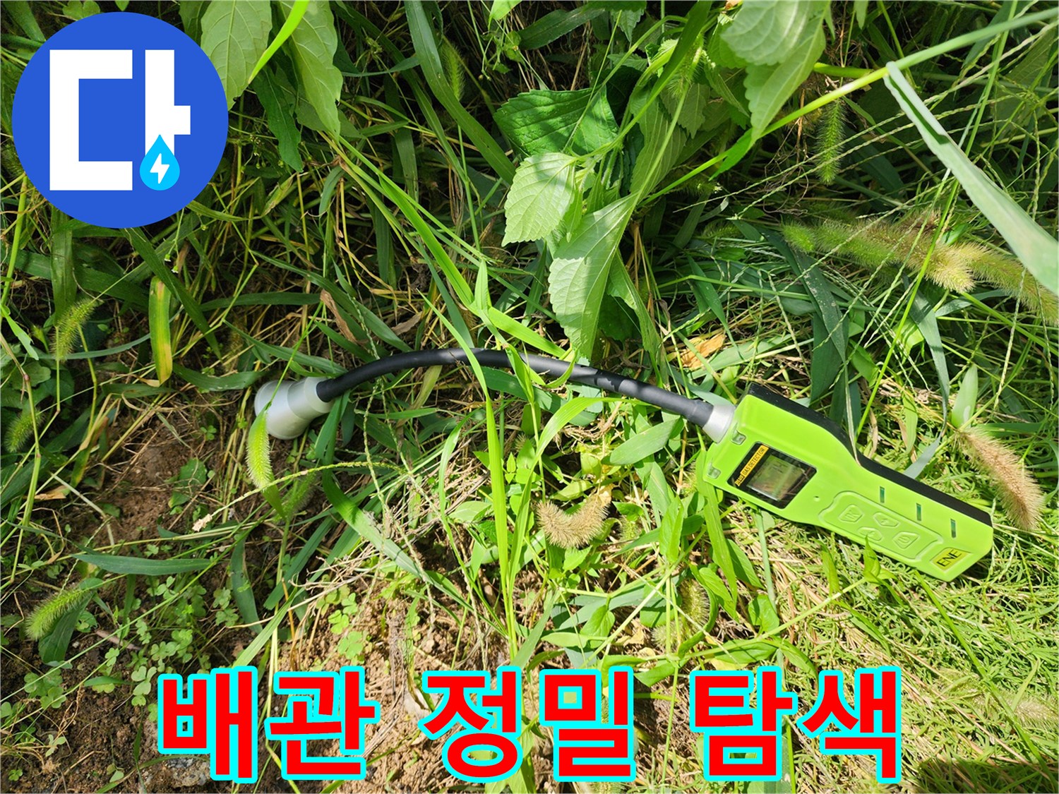 풀숲에 놓인 가스식 누수 탐지 장비와 호스