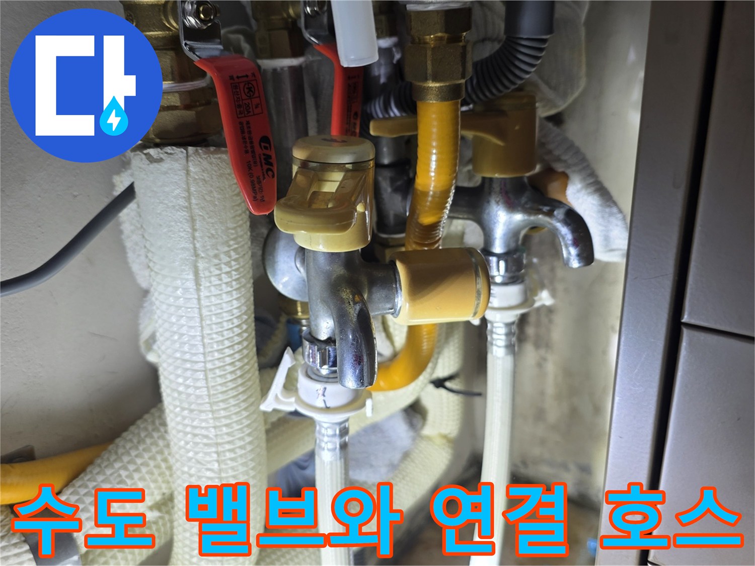 주방 싱크대 하단 수도 밸브와 노란색 보호재가 감긴 배관 부위