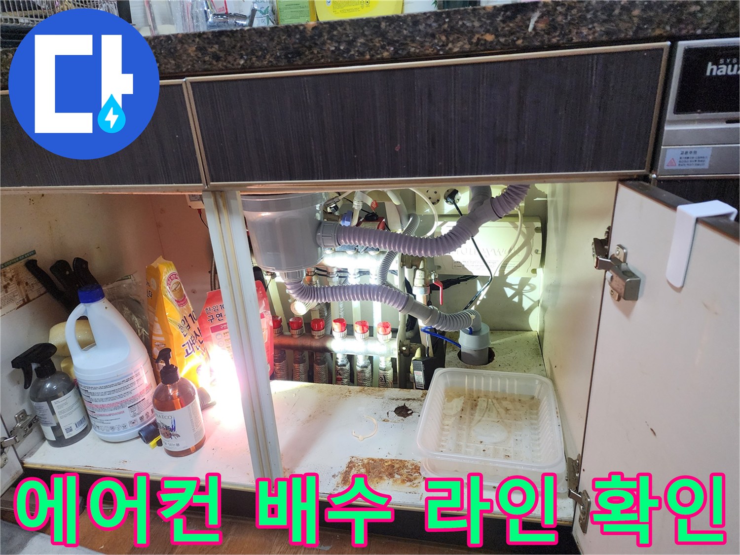 싱크대 밑 에어컨 드레인 호스와 연결된 배관 부위
