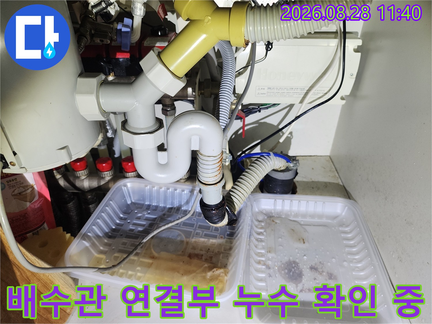 싱크대 하단 배수 트레이와 물이 고인 배관 연결 부위 촬영