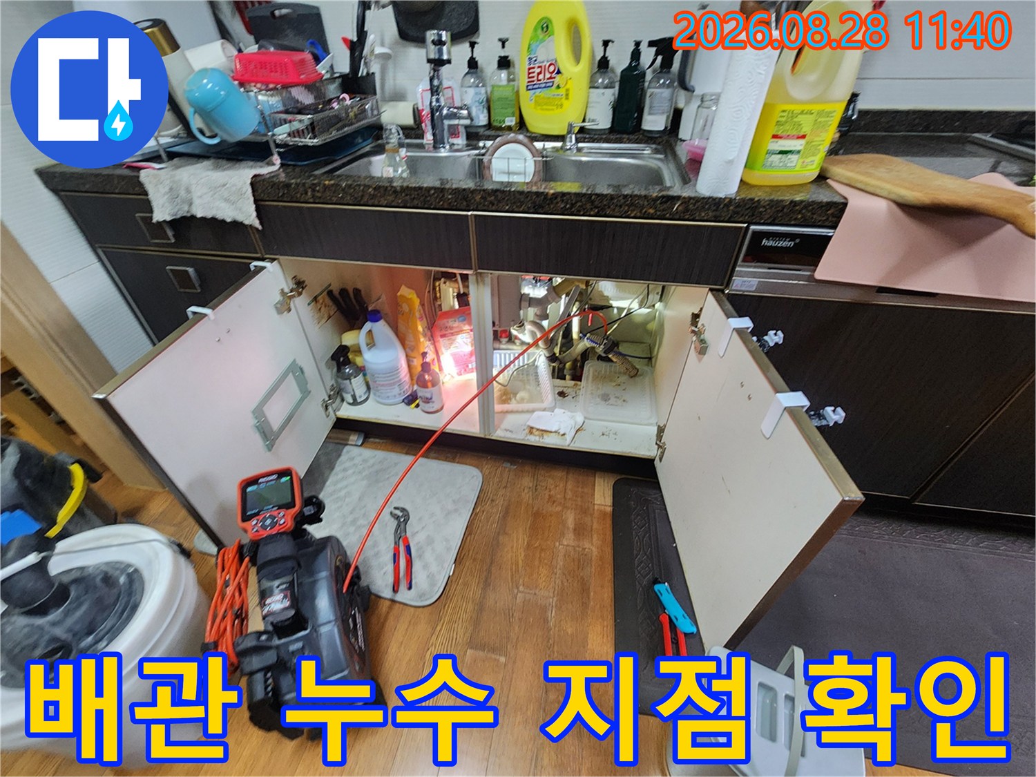 싱크대 하부의 배관 연결 부위를 중심으로 누수 여부를 꼼꼼하게 조사하는 모습입니다.