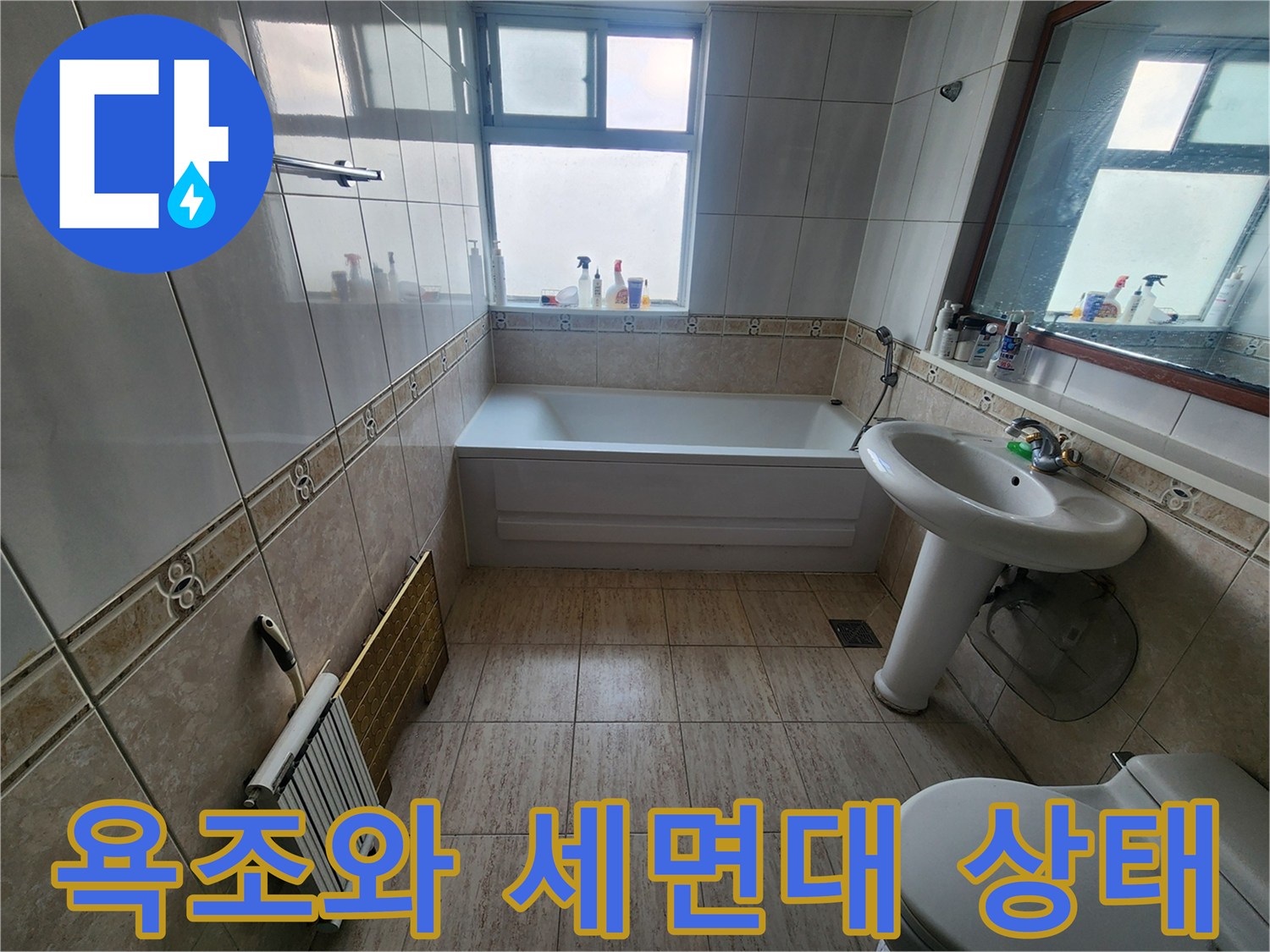 세면대와 욕조가 설치된 화장실 내부의 전체적인 모습입니다.