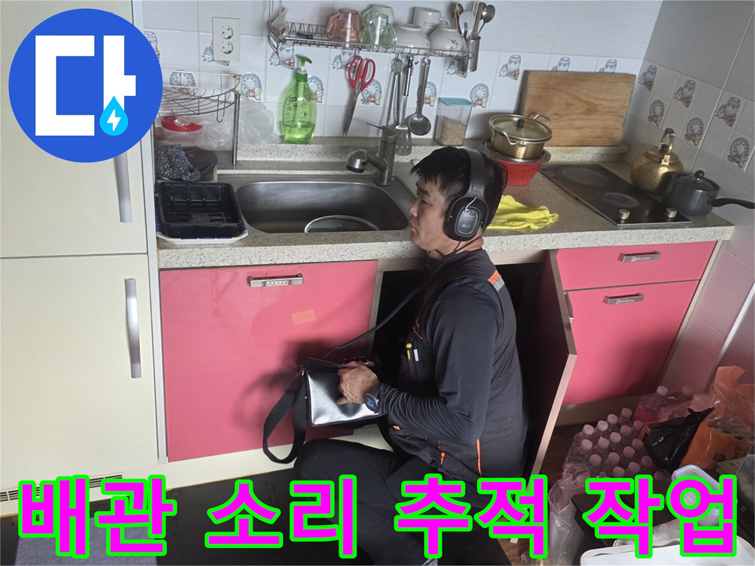 청음 탐지기를 활용하여 싱크대 밑 배관의 누수음을 정밀하게 듣는 모습입니다