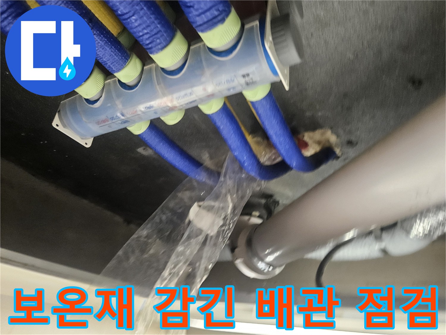 파란색 보온재가 씌워진 다수의 배관과 흰색 대형 파이프