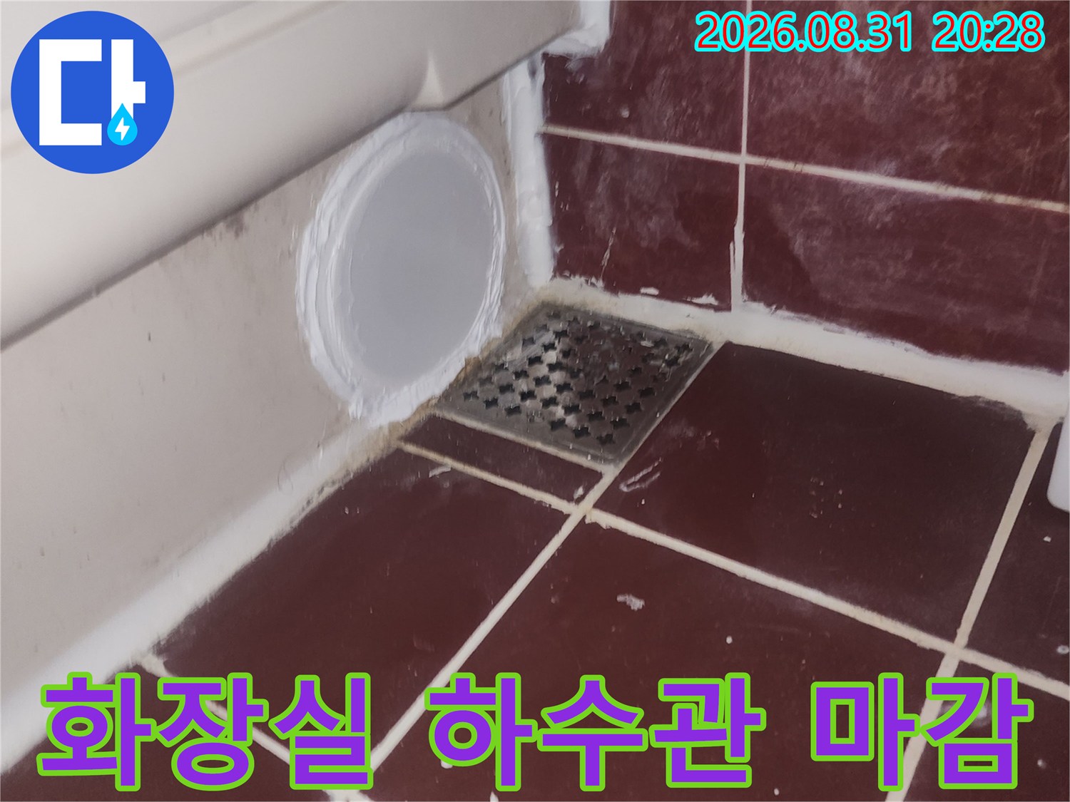 붉은색 타일과 하수구 유가 주변의 배관 마감 상태를 보여주는 사진
