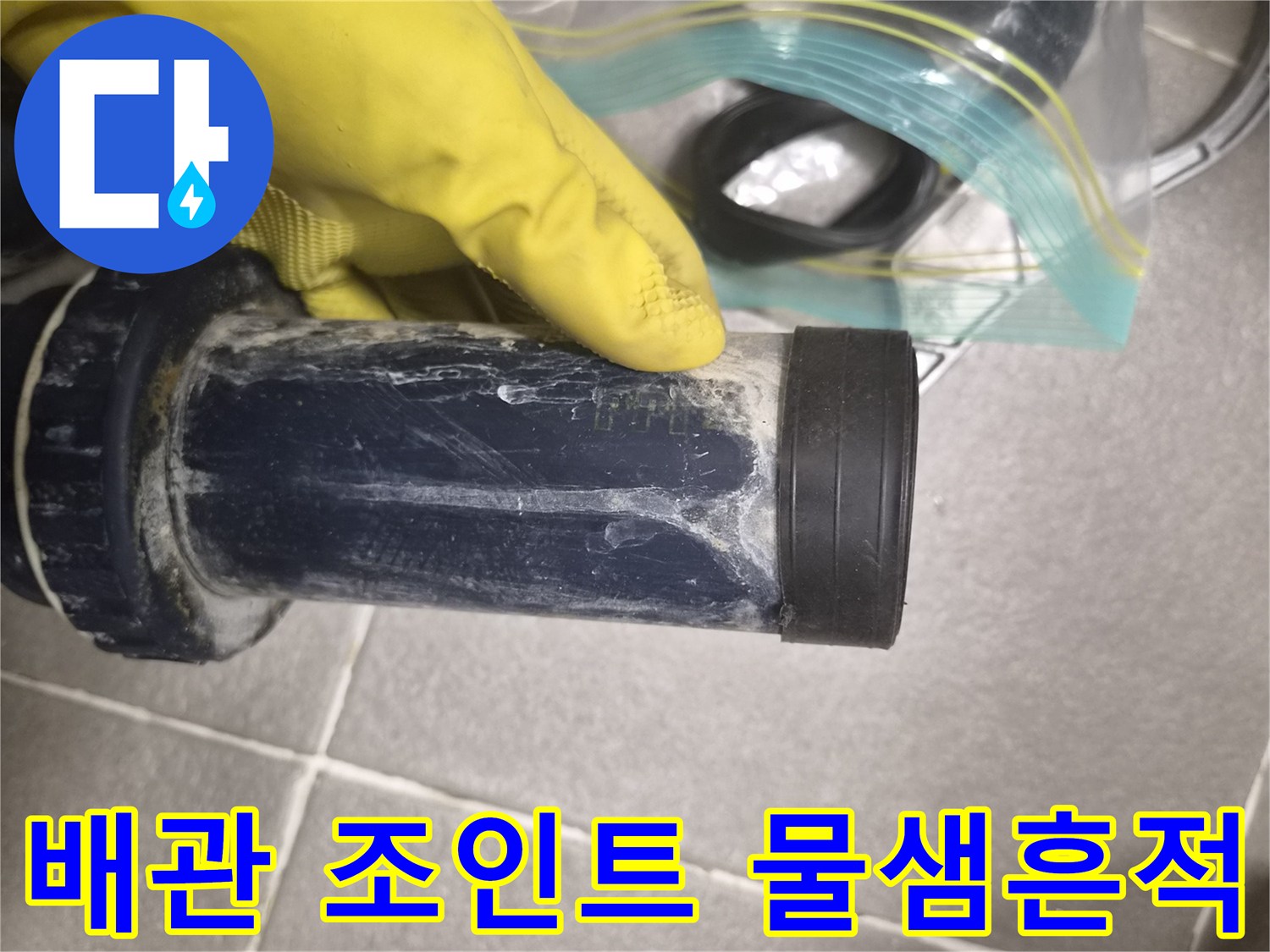손으로 배관의 누수 지점을 점검하고 있는 장면